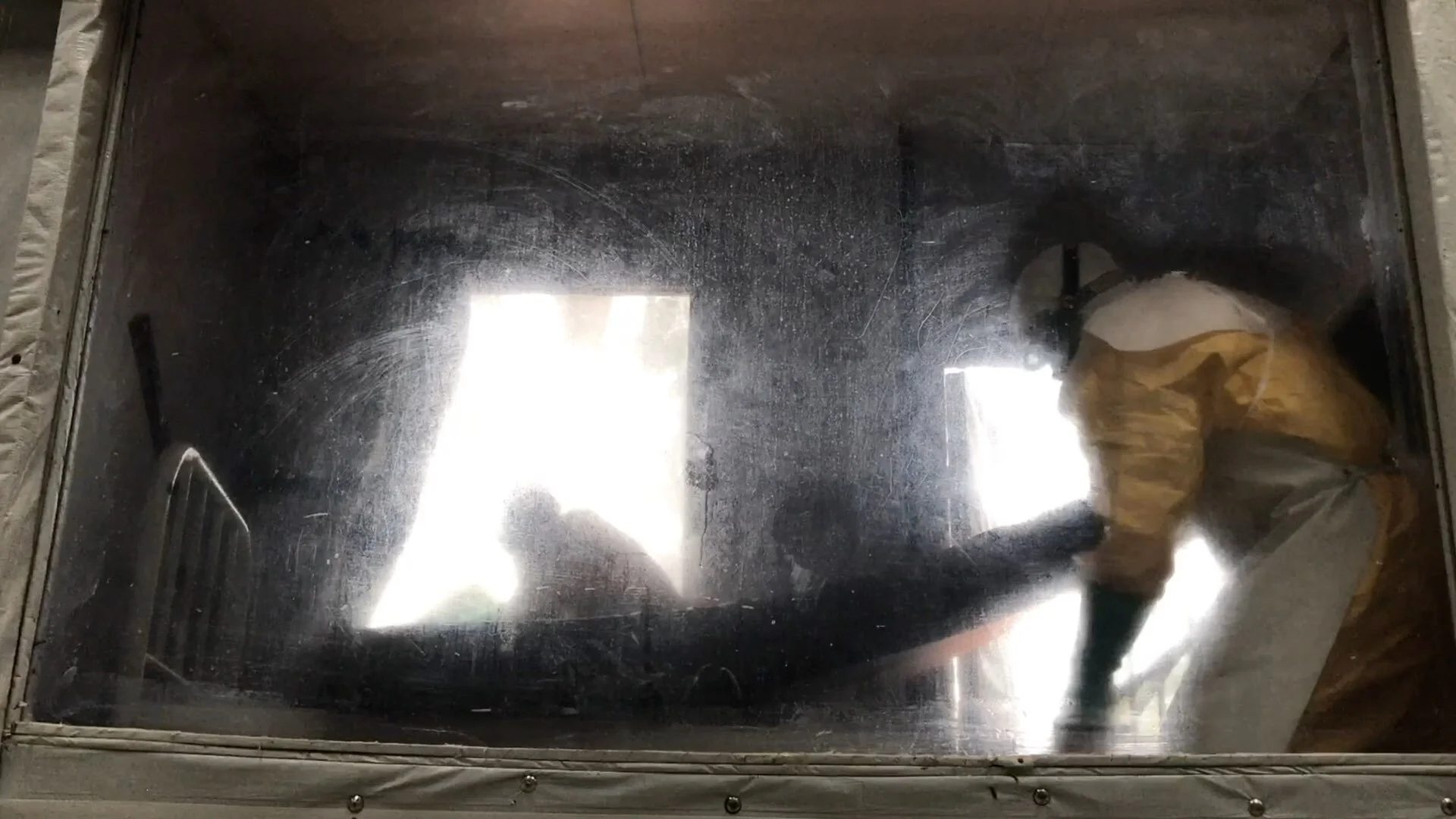 Health workers in protective suits decontaminate a patients ‘room’ at the Ebola Treatment Center in Katwa near Butembo. Teams of workers get the trained hygienists ready to go into the quarantine zone to and sterilize every room, every day. An empty…