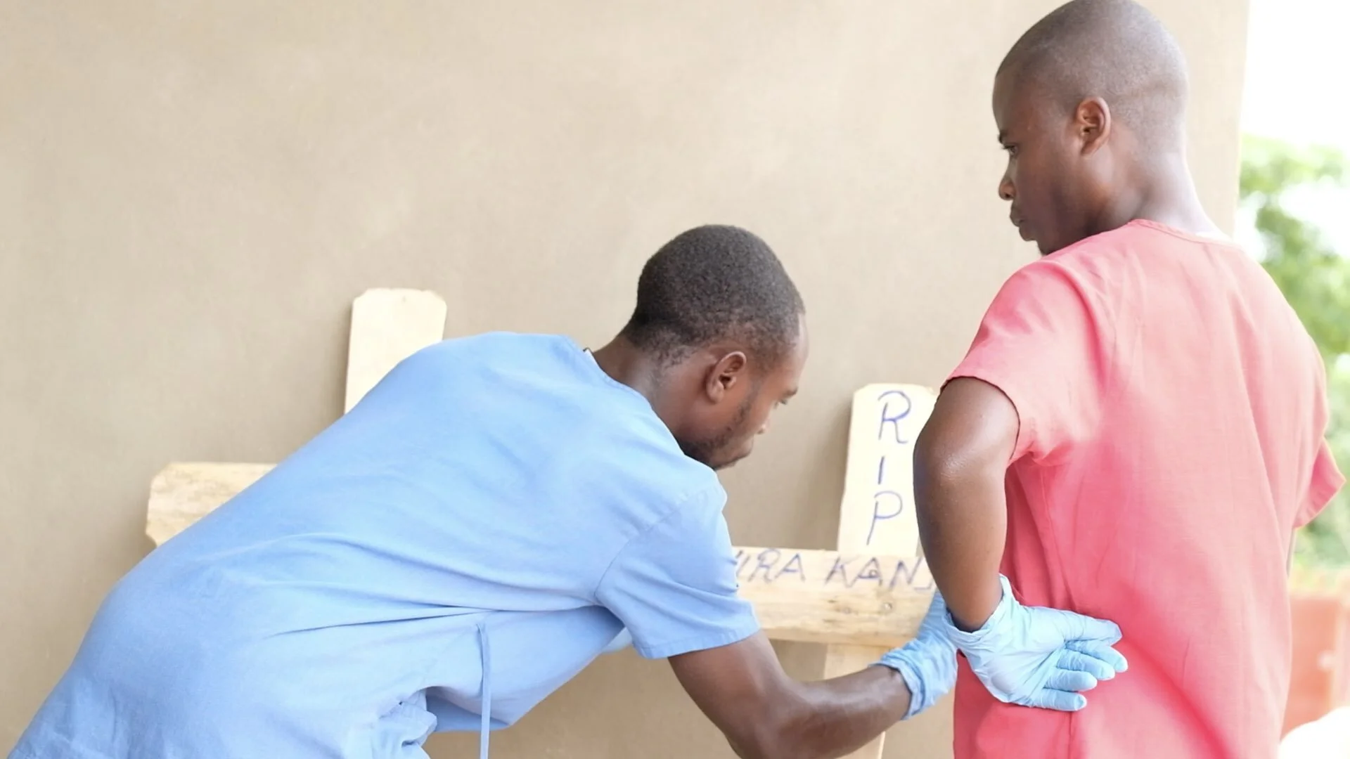 Health workers mark the name of the child on the cross before they transport the body to the burial site. When handling the body, the teams wear protective equipment for all deaths in the hospital as a precaution against Ebola. Families are allowed …