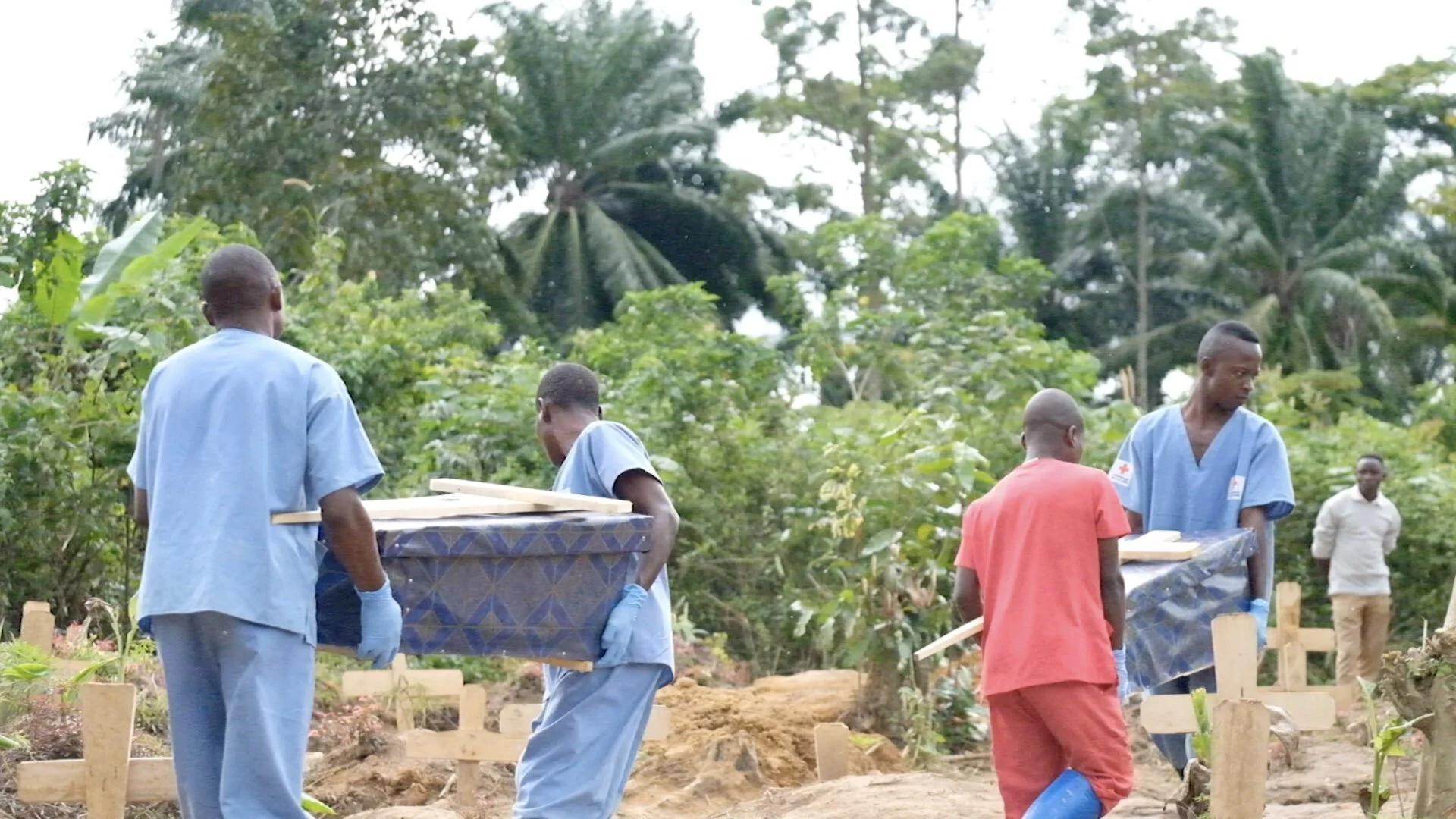 Health workers carry the two small caskets holding newborn twins who didn’t survive. Burials on all reported deaths, even without Ebola, are carried out by the specially trained teams, but some families don’t report deaths and still bury the family …