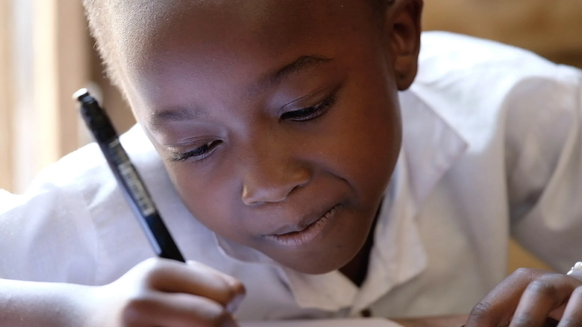 Lorene is 8 years old. She and her sister survived Ebola together in quarantine. They lost their mother but they’re recovering and back in school. This is Lorene drawing a self portrait with a chicken.