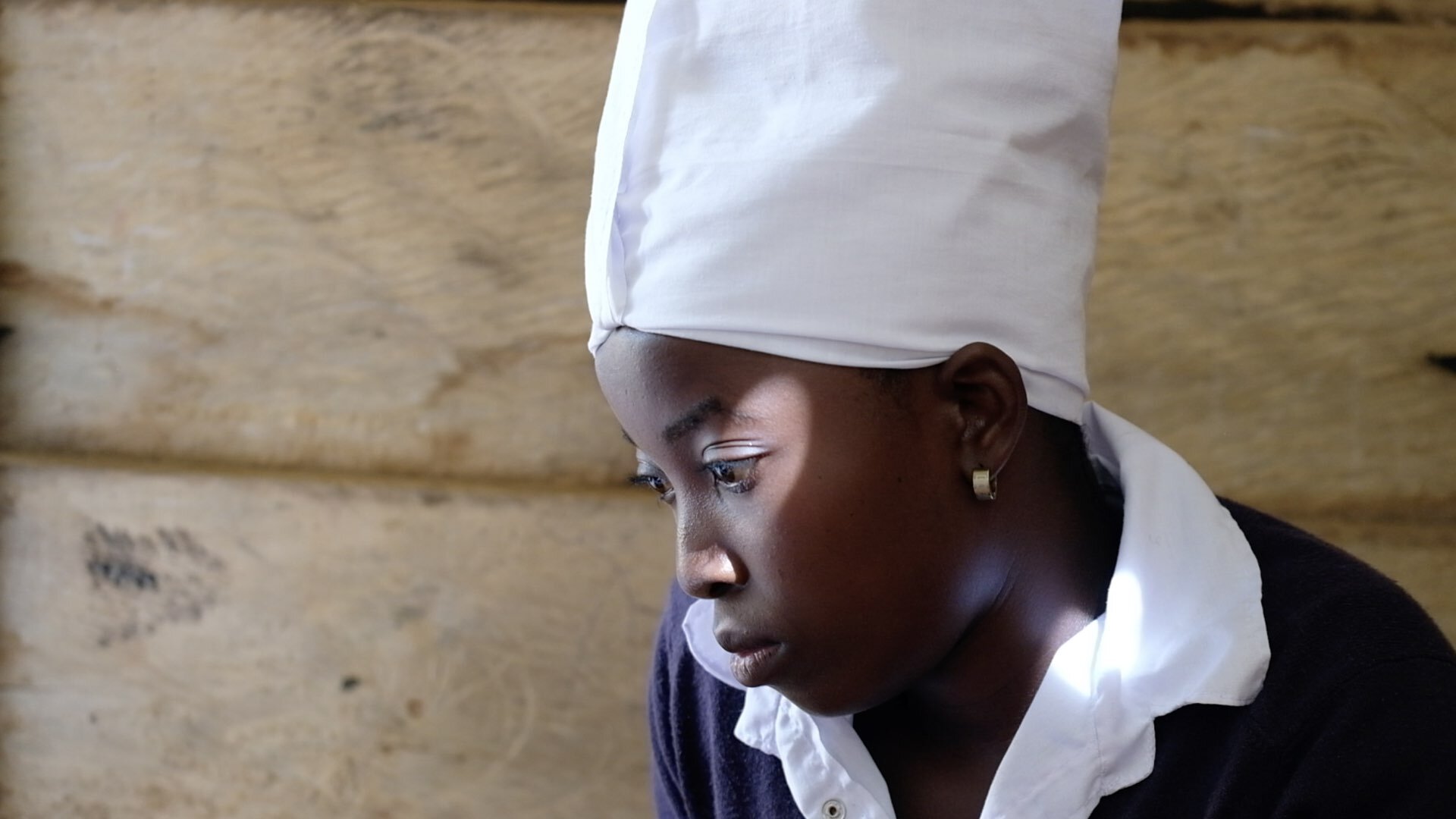 Oripa watches as Lorene draws her own portrait. The girls get support from UNICEF with school and medical bills and counselling and healthy food. Without the help, the fate of Ebola survivors would be even more difficult than it already is.