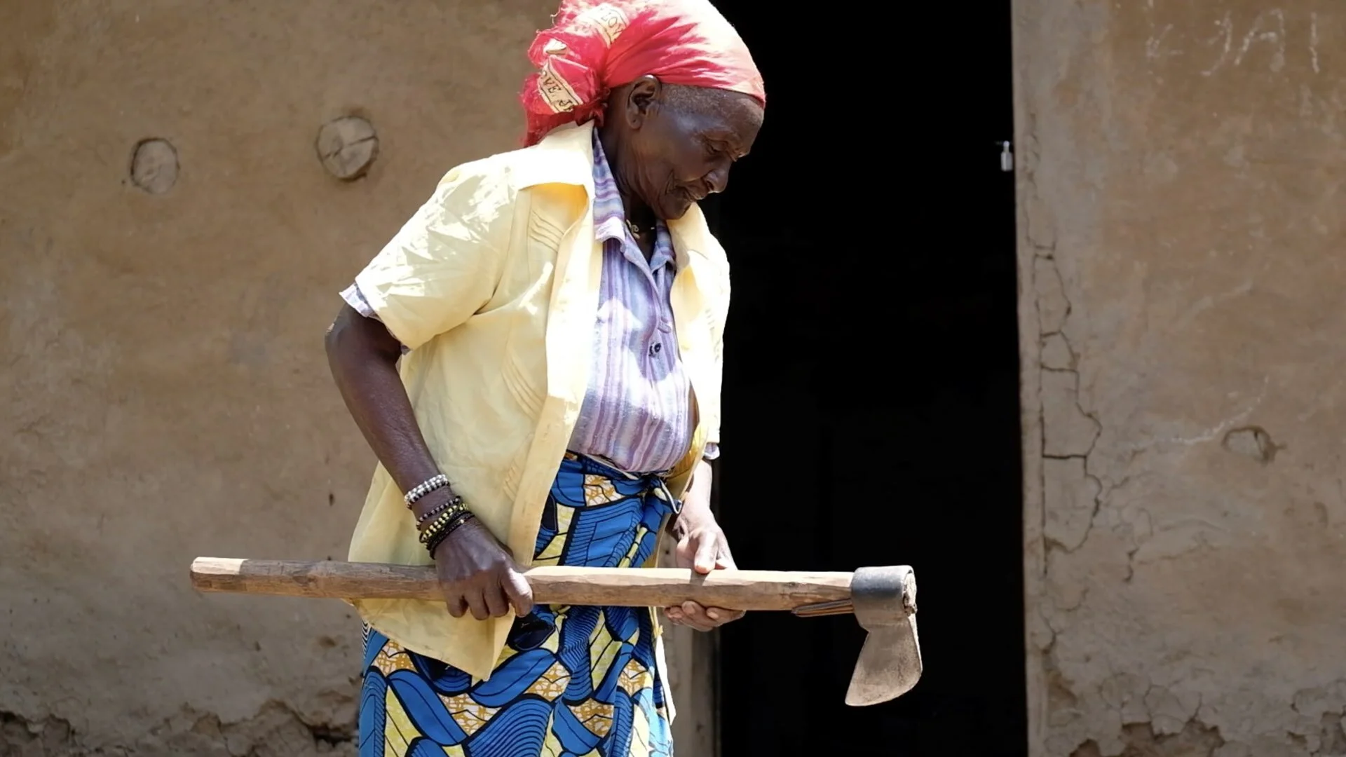 Veronique used to live on a farm in Kibira and she says that her strength from farming helped her beat Ebola. She chops the wood to get a fire going to make the evening meal for the hungry children. Between getting firewood and water, laundry and co…