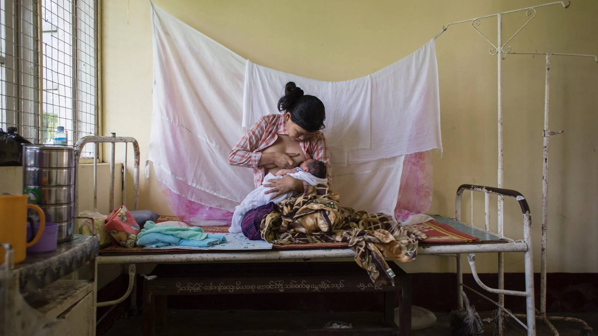 Myanmar: Ei Ei Phyo breastfeeds her newborn son on a cot in Hlaing Thar Yar Hospital in Hlaing Thar Yar Township in the city of Yangon, capital of Yangon Region. The baby, born the evening before, is her first child. ©UNICEF