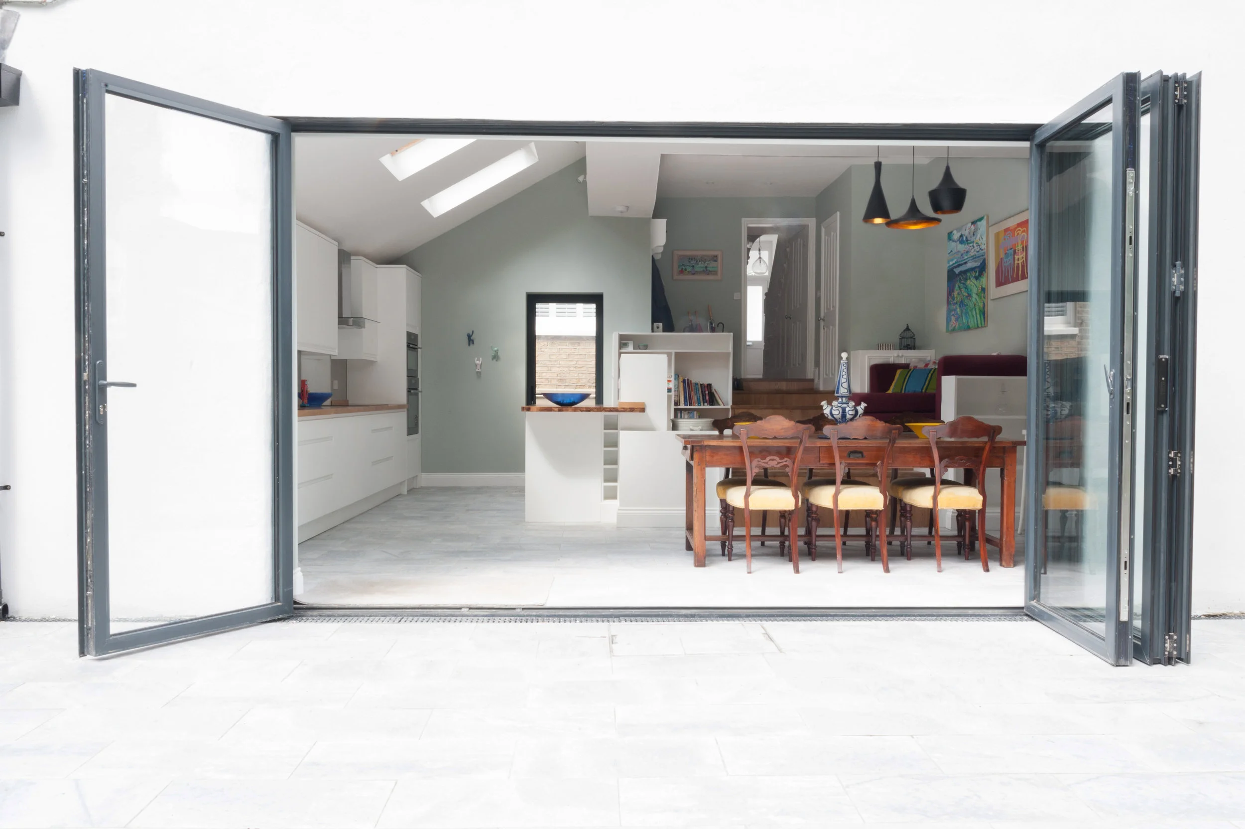 View from garden through bifold doors into large kitchen, dining, family room.
