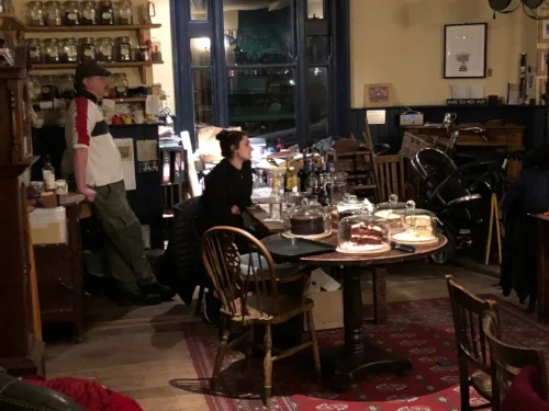 Harry, the Teahouse owner, & Ariane down tools and listen.