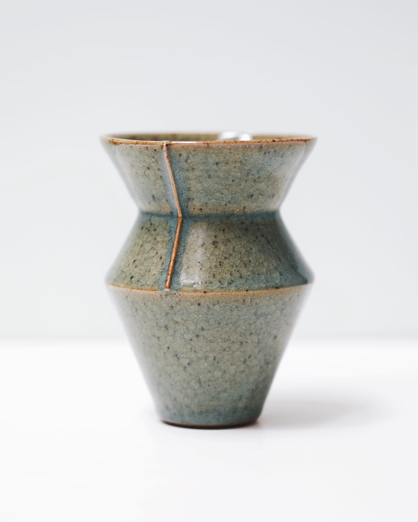 A lined vessel, more angular than most, marked with a line that travels from the rim downward. The rims of my pots coated with the dark green crackle glaze always break to reveal a wonderful, almost metallic orange hue and this sharp protrusion on th