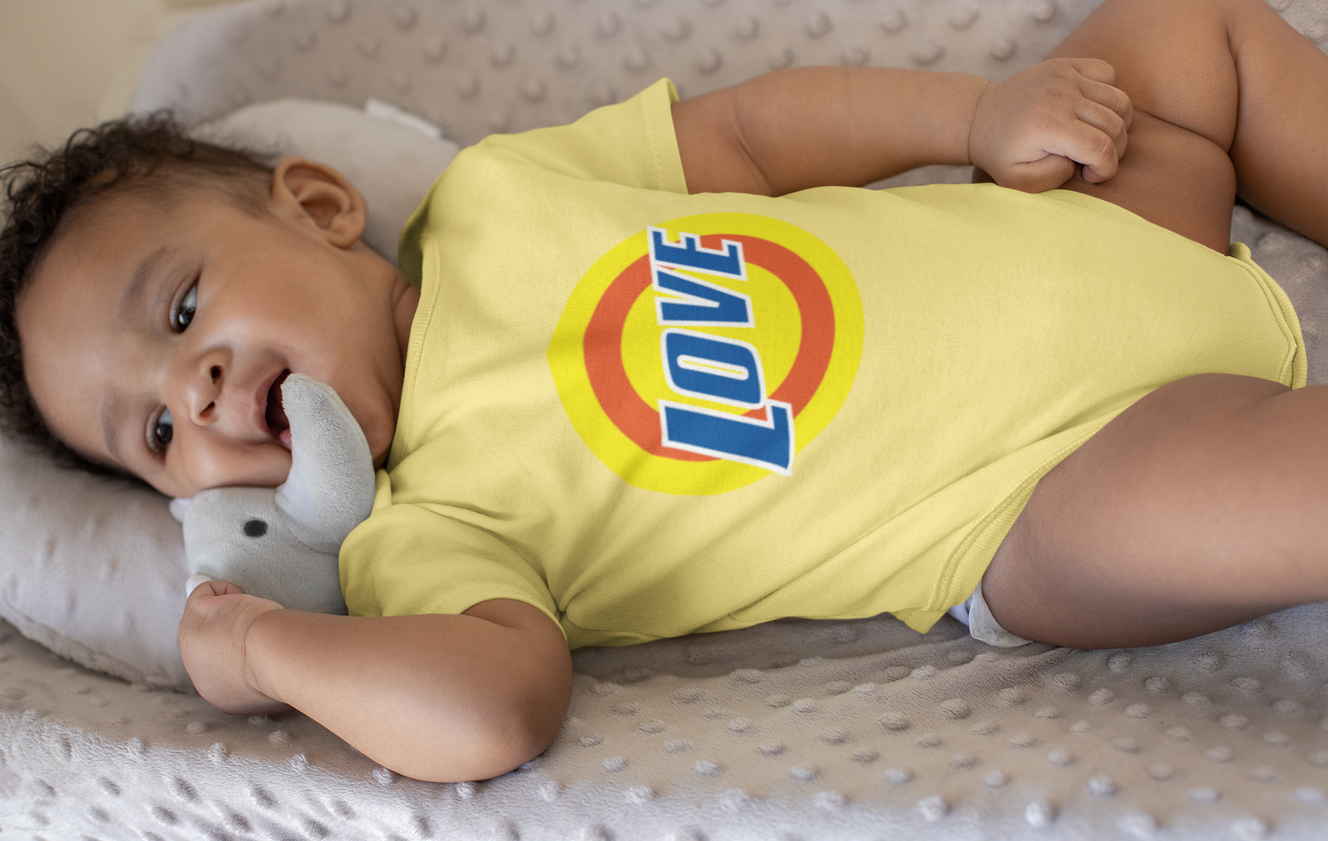 onesie-mockup-of-a-baby-boy-lying-on-a-soft-cushion-25113.png