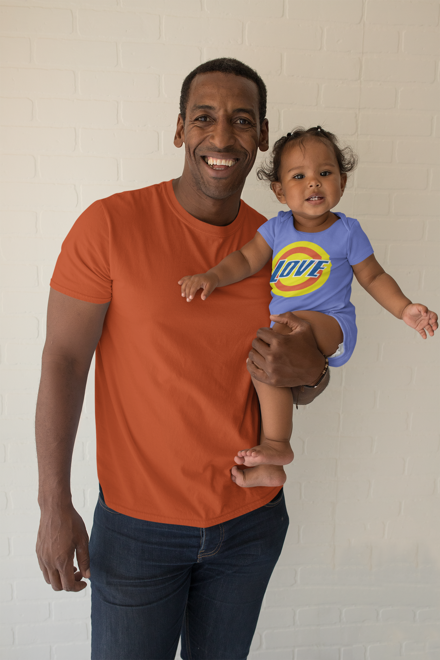 mockup-of-a-smiling-man-with-a-t-shirt-holding-her-baby-girl-in-a-onesie-28067.png