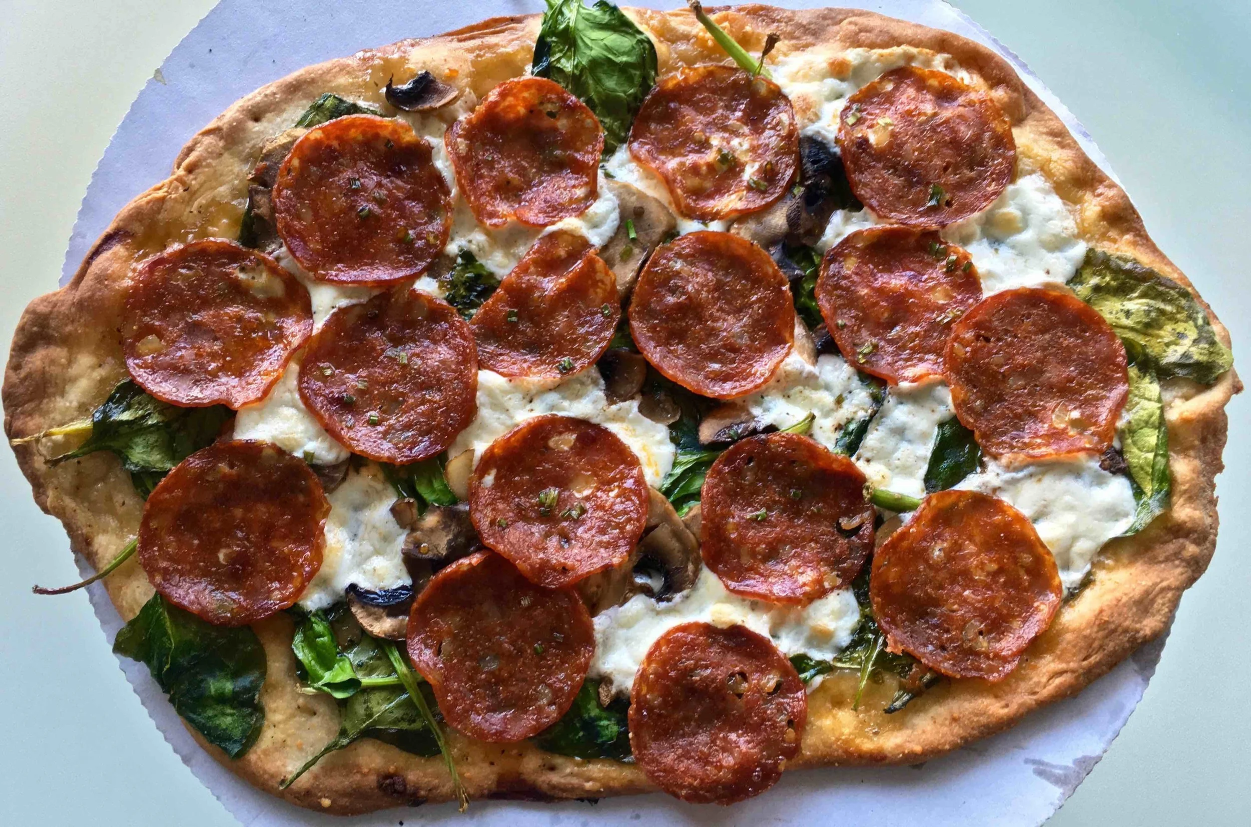 cooked up spinach and mushroom pizza with pepperoni
