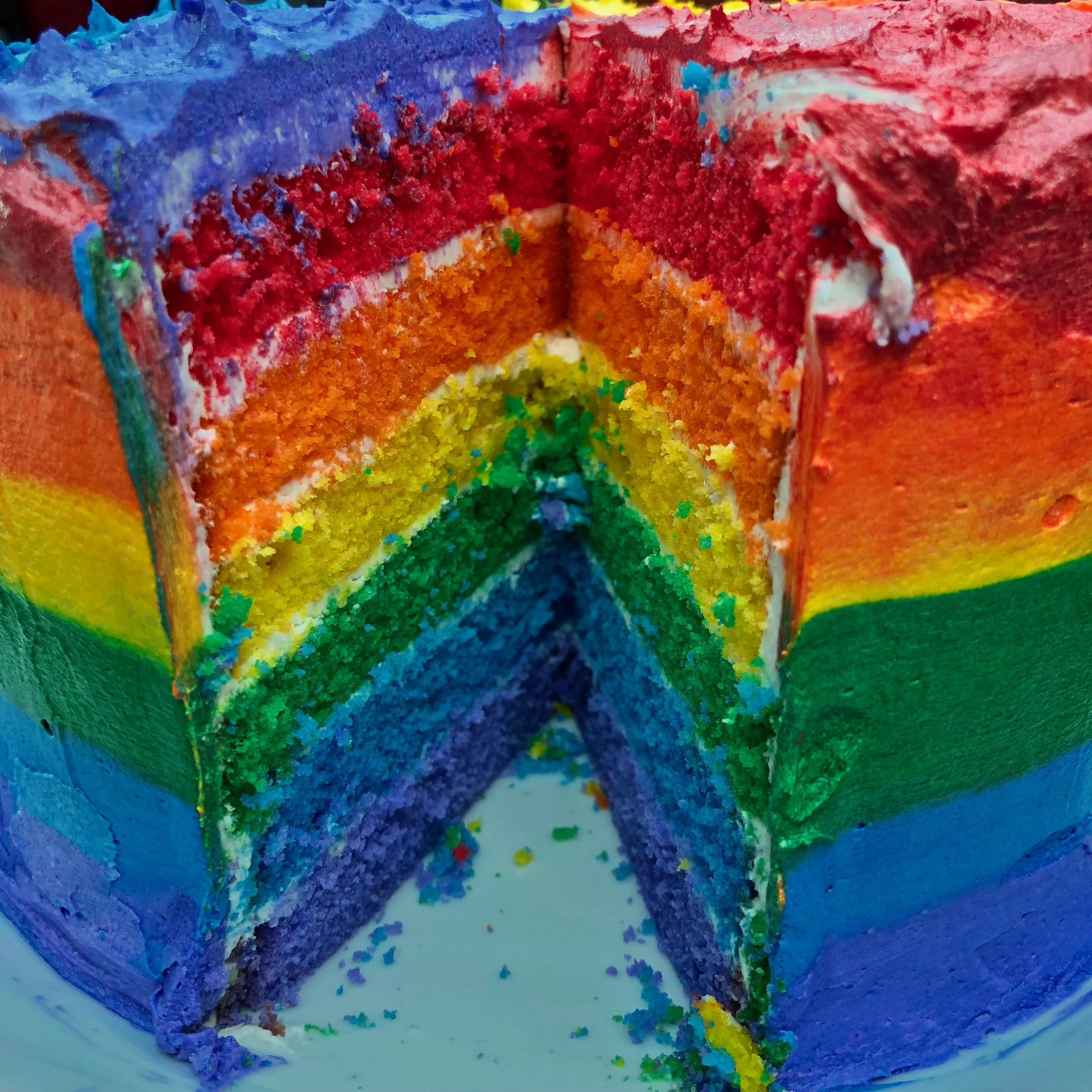 inside a rainbow frosted rainbow cake