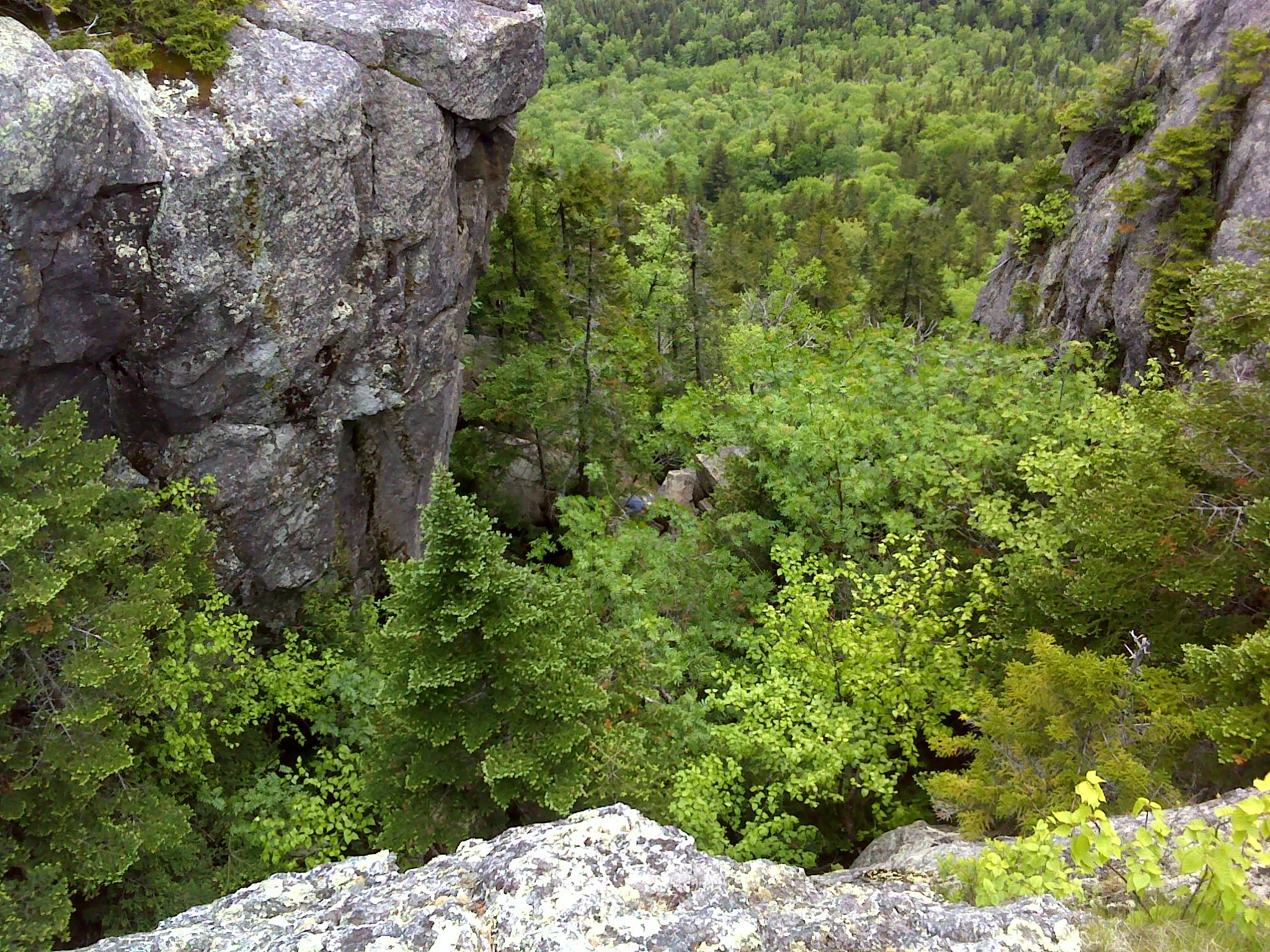 Looking down the chimney from the top. You can see a hiker standing on top of the boulder choke in the center of the frame