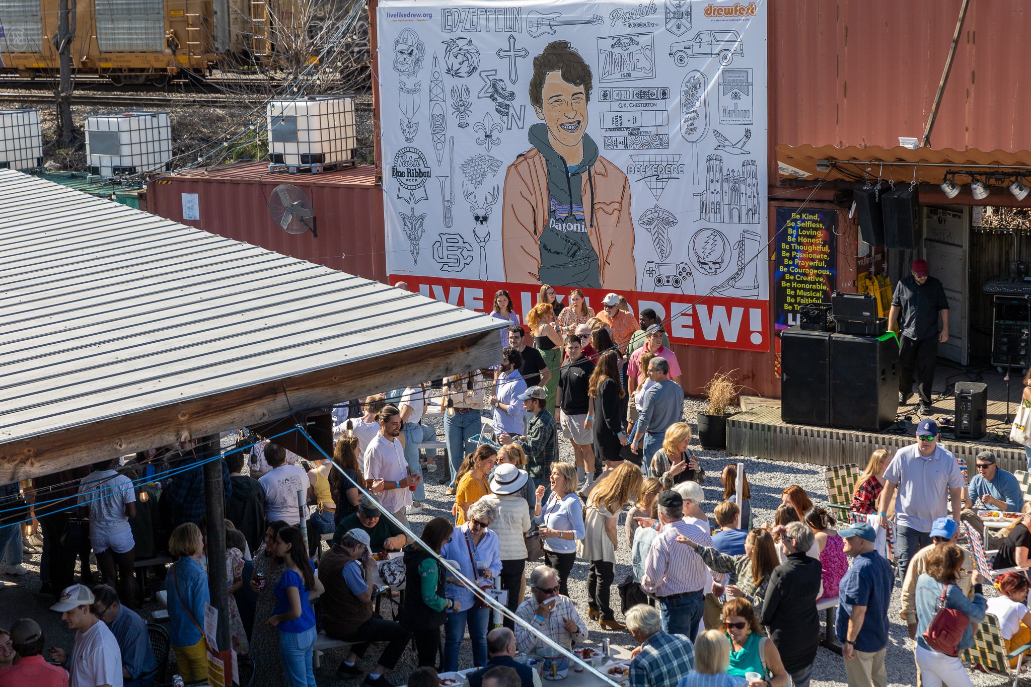  DrewFest Memphis event banner wall  Railgarten  Branding creative and design by Chuck Mitchell  Pro bono project celebrating the life of Drew Rainer  Illustration by Fiona Bono  Photograph by Bryant Cummings 