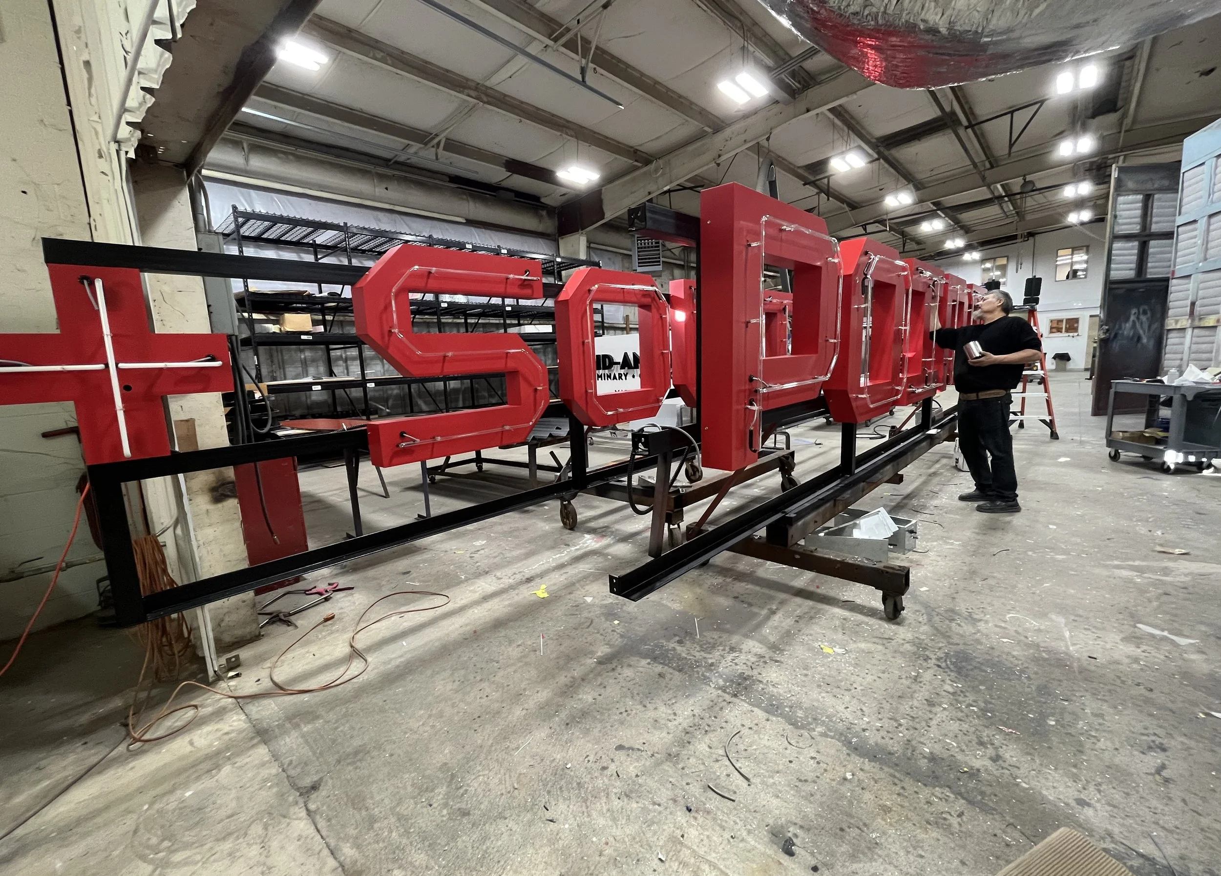  South Point Grocery Silo Square  Southaven, Mississippi  "SOUTH POINT" exterior neon sign in production  Branding creative and signage design by Chuck Mitchell  Sign fabrication and installation by Frank Balton Sign Company 