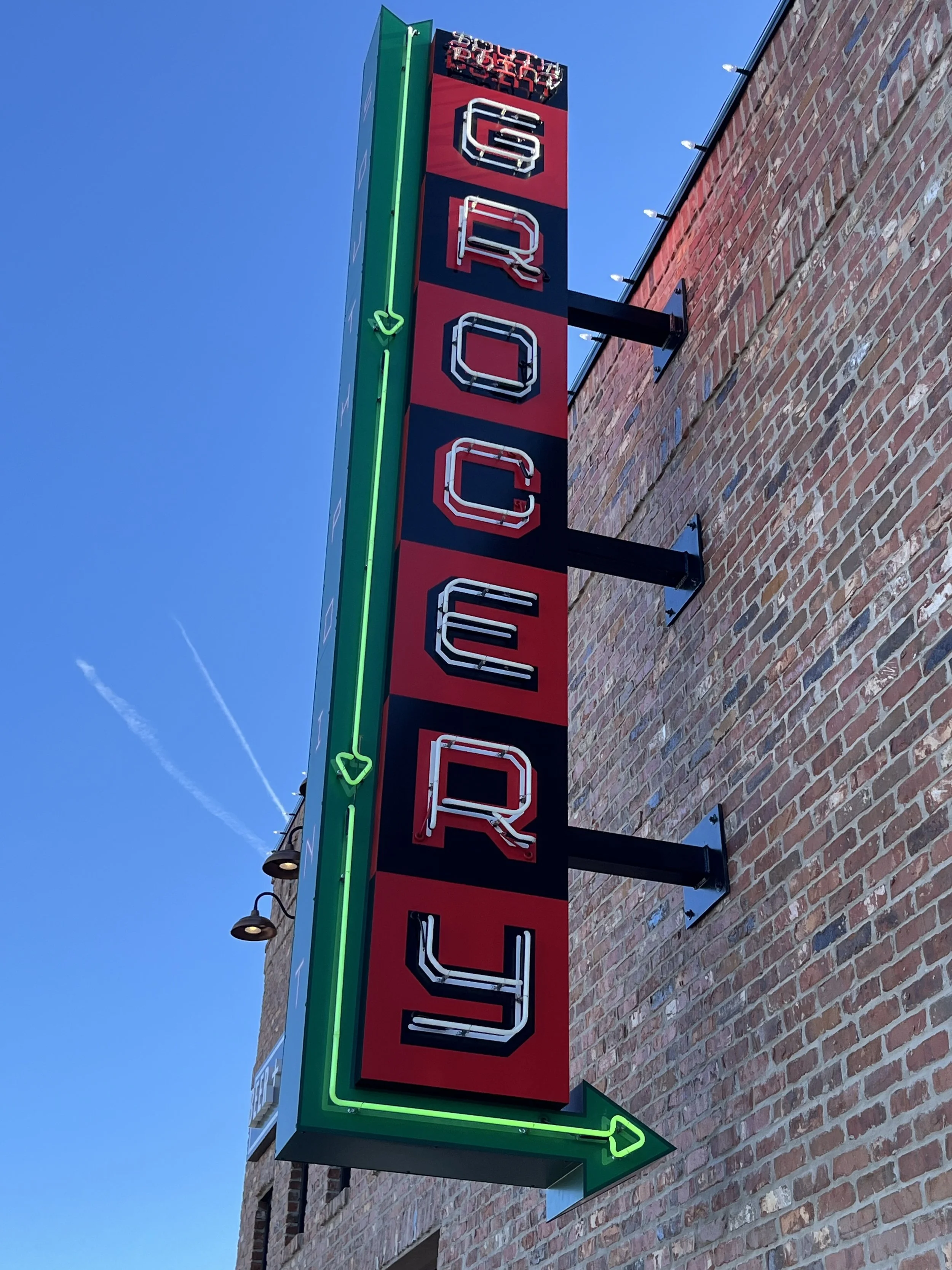  South Point Grocery Silo Square  Southaven, Mississippi  "SOUTH POINT GROCERY” main entrance neon blade sign  Branding creative and signage design by Chuck Mitchell  Sign fabrication and installation by Frank Balton Sign Company 
