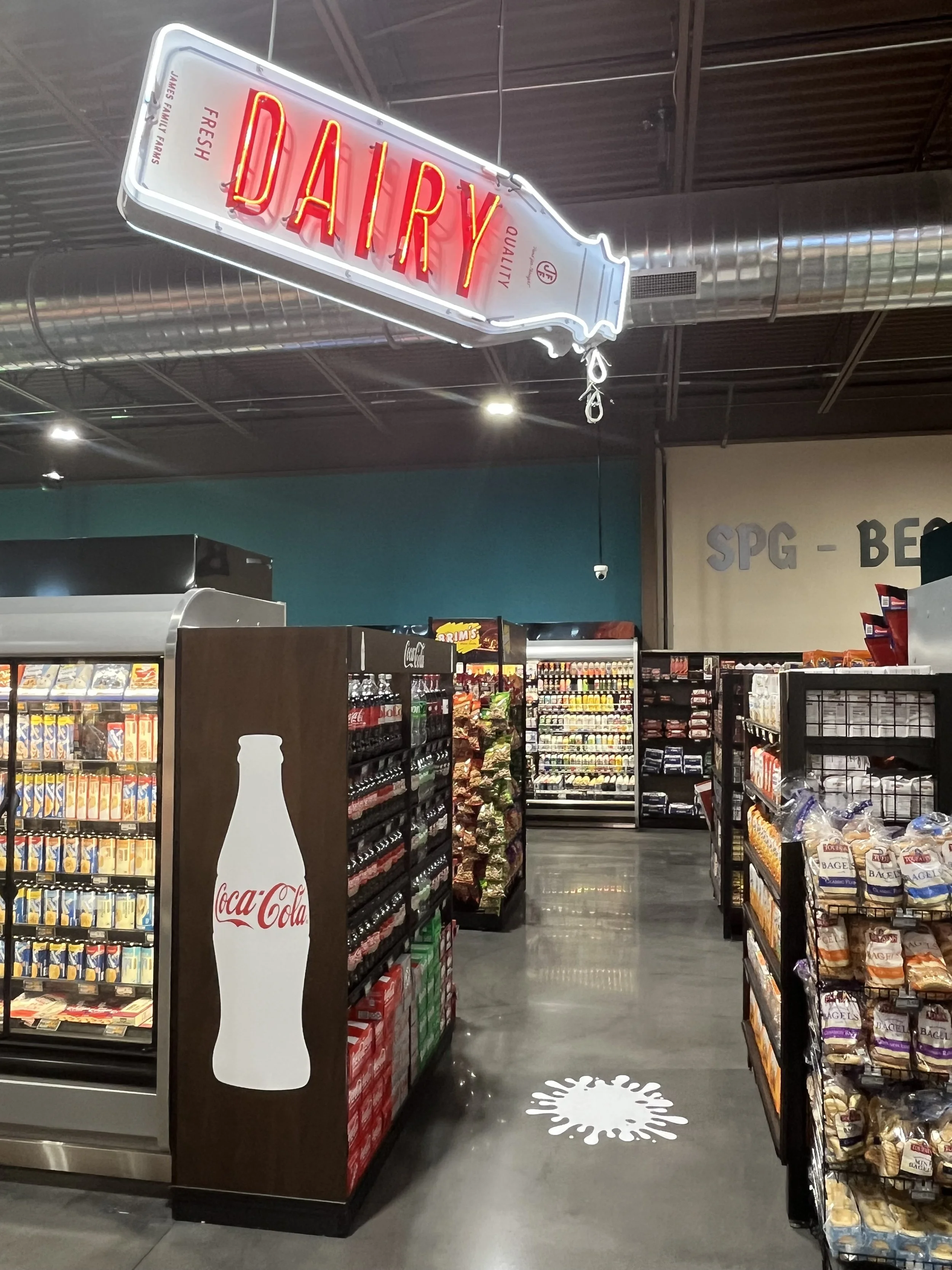  South Point Grocery Silo Square  Southaven, Mississippi  "DRIPPING DAIRY BOTTLE" interior double-face neon sign with motion  Branding creative and signage design by Chuck Mitchell  Sign fabrication and installation by Frank Balton Sign Company 