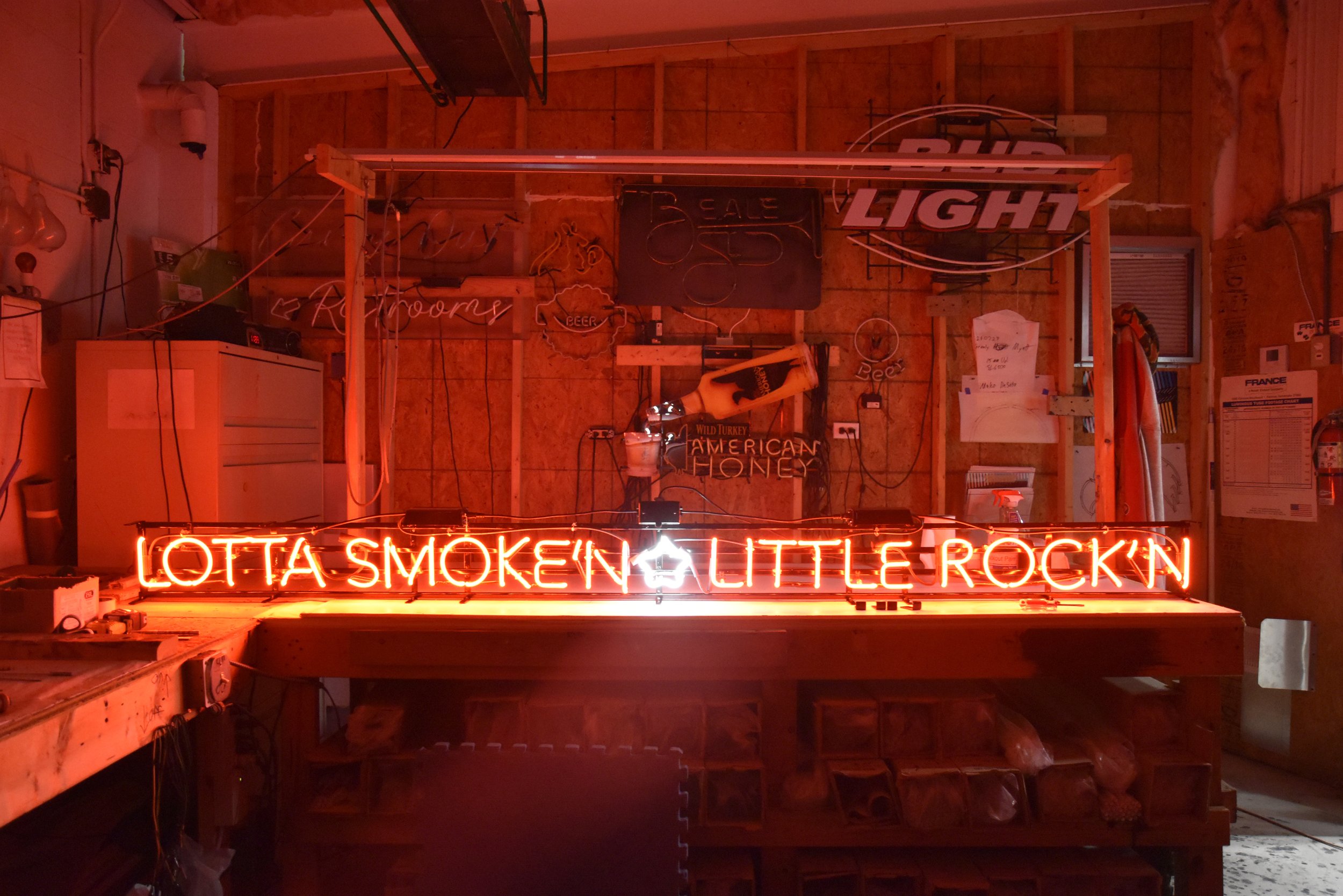  Back Home Barbecue  Little Rock, Arkansas  West face smokehouse wall neon in production with tag-line “LOTTA SMOKE’N - LITTLE ROCK’N” created and written by Chuck Mitchell  Branding and signage package design creative developed by Chuck Mitchell and