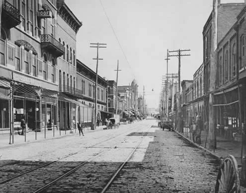 1905 - 1906 First Greek Orthodox Church Church of Atlanta, 113 1/2 Whitehall Street (Top Floor) The Church services were held in the top floor of the 3 story building with the decorative roof to the right of the man standing in the street
