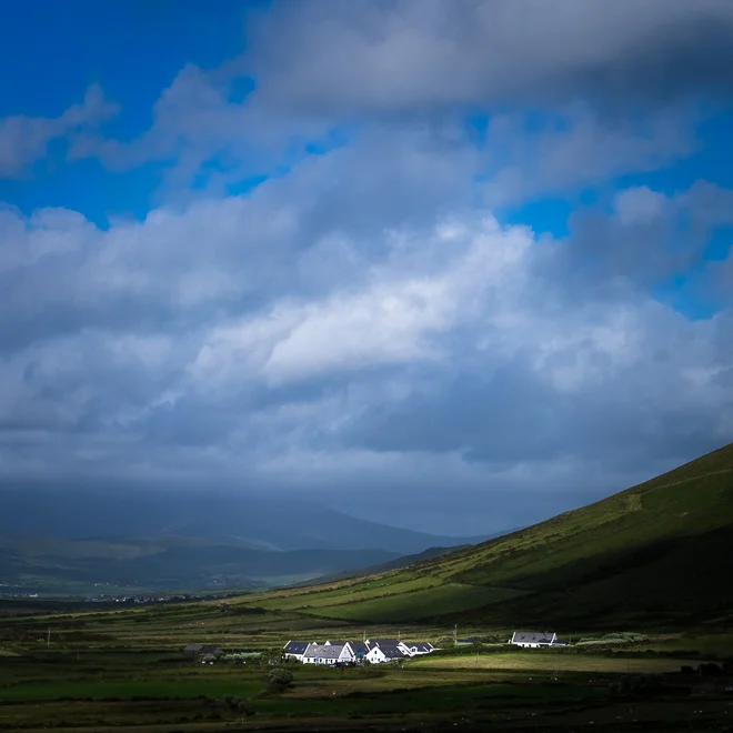 The subject (the houses) are the brightest element in the image, and so carry greater visual weight. They are balanced by the vast expanse of sky which echoes the white. It's not a 50:50 'space taken up in the frame' balance - it's a counterpoint of tone and texture. It's also a balance of man-made vs the natural world, the insignificant vs the universe, the transient vs the permanent, if you want to go that deep.