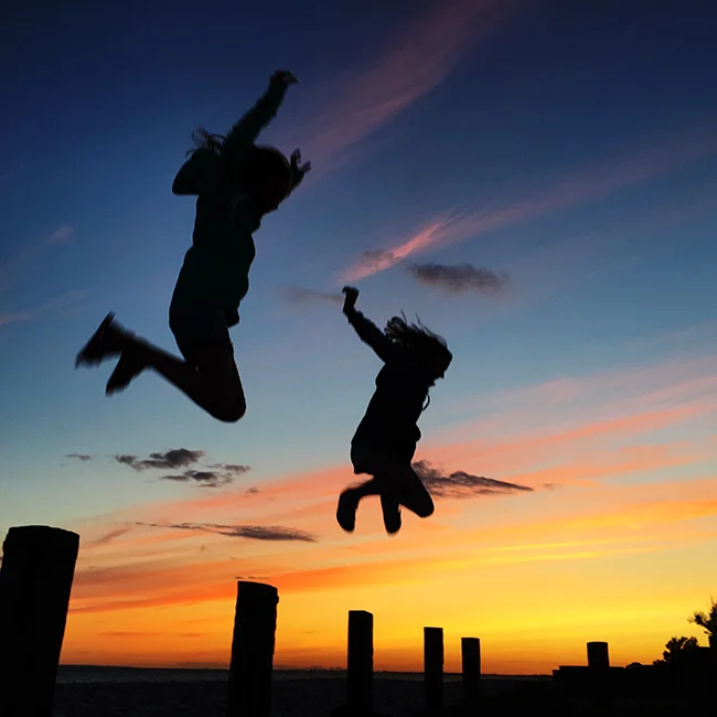 This image balances the saturated colour of the evening sky with the silhouettes of the jumpers and the bottom fence/hedge detail.
