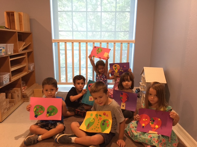 Our youngest campers proudly show off their colorful hot air balloon collages.