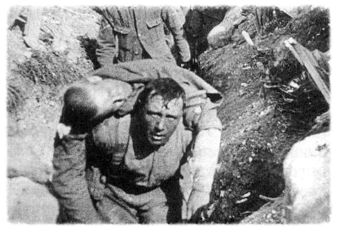 A British soldier carries a mortally wounded comrade to an aid station.
