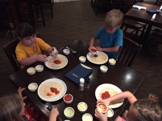 Campers create edible art on their pizza dough canvases.