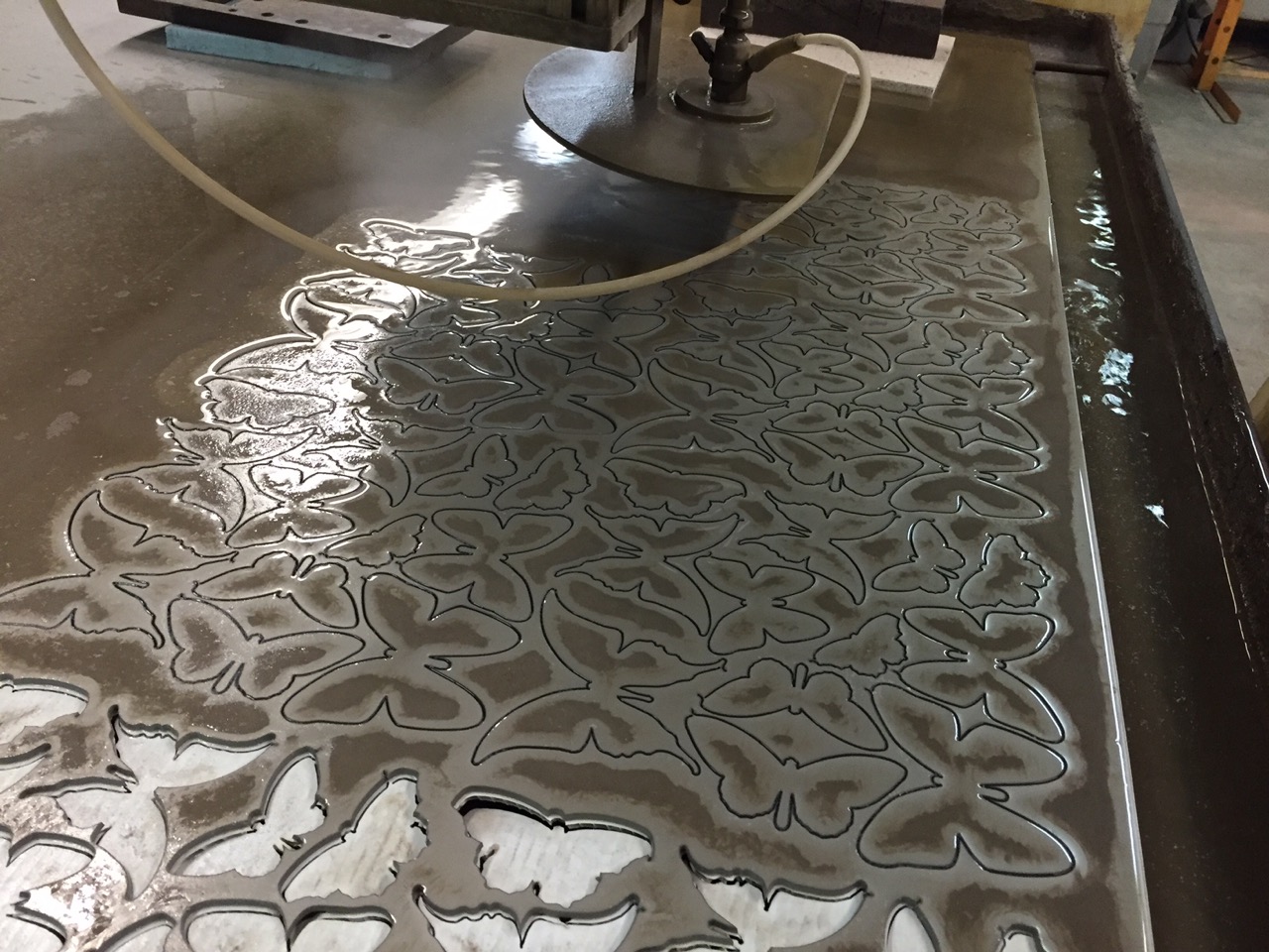 It’s an amazing process. It combines water that is sprayed at 45,000 psi combined with garnet abrasive. The dark in the center of the shapes is the garnet residue.