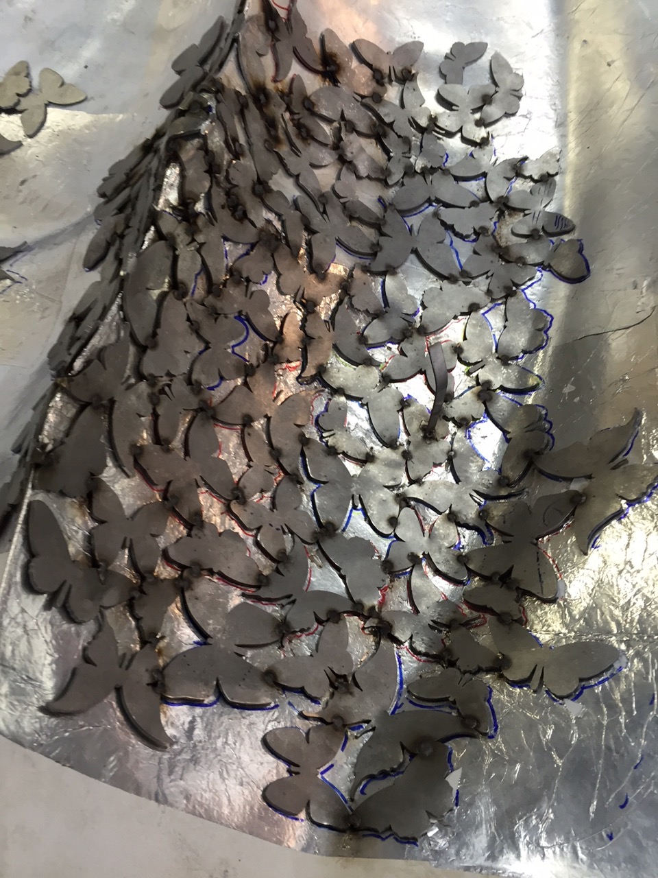 We are hand forming each individual butterfly to match the contour of the mold and welding it from the back.