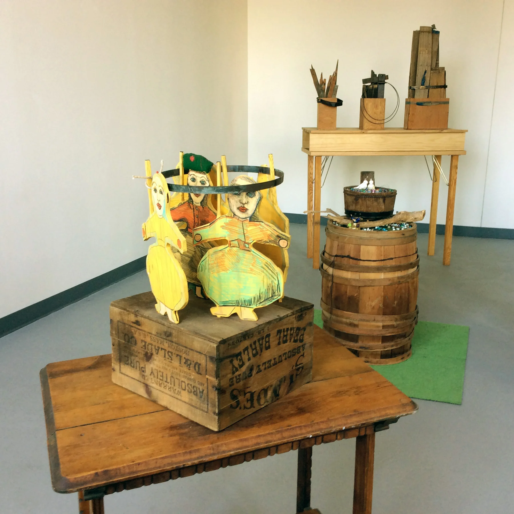 Gallery Installation 2015. Front: Paper Dolls , 2011. The cut outs of dolls are from 1985. Middle: S&P Birds , 2010. The top surface of the piece is full of glass beads mixed with ceramic birds placed in a wooden bucket and on the surface of a barrel. Back: Three Parts, 2004. 48"W x38"H x 17"H.