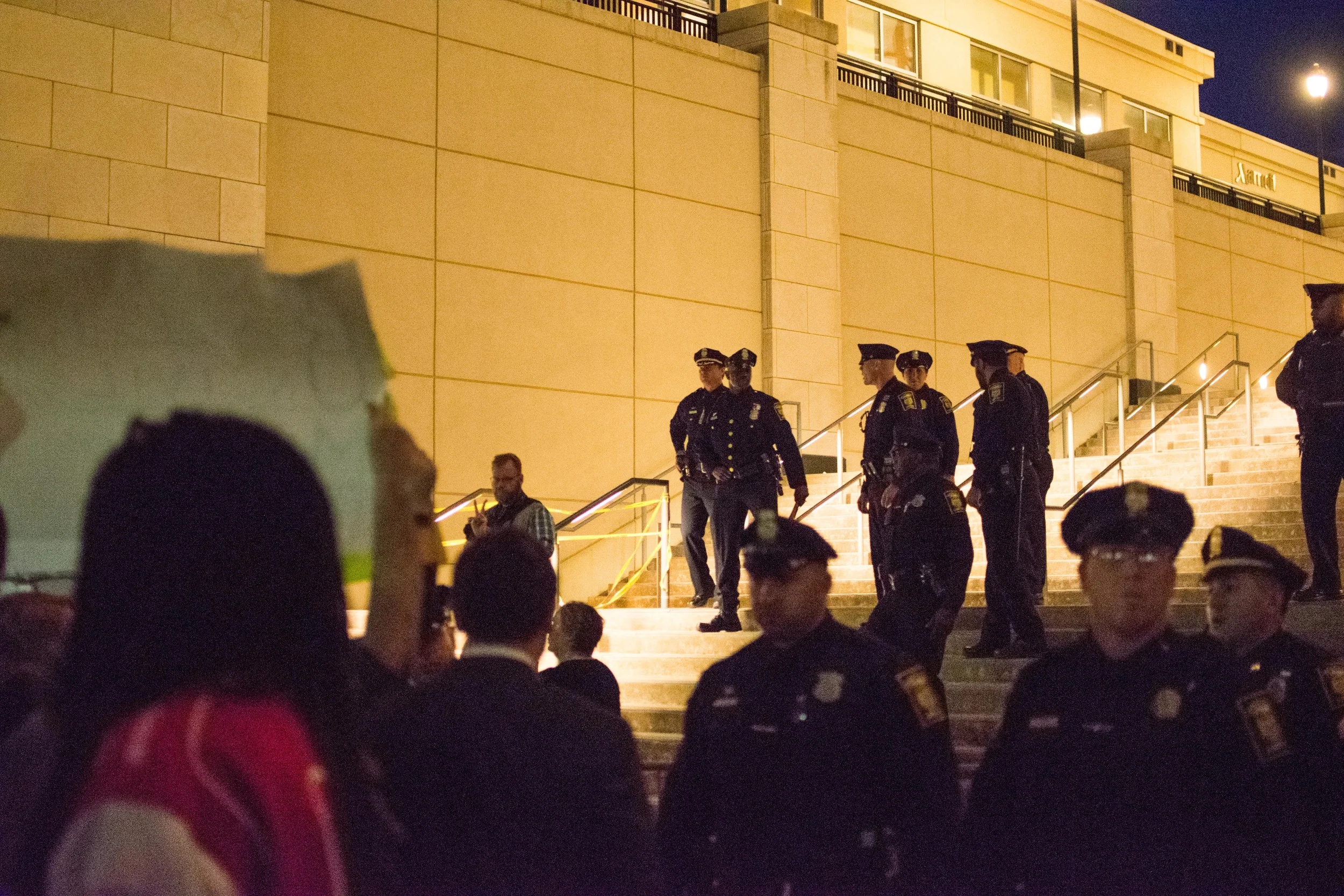 Officers from the Hartford Police Department act in a skirmish line, moving protestors off the sidewalk.