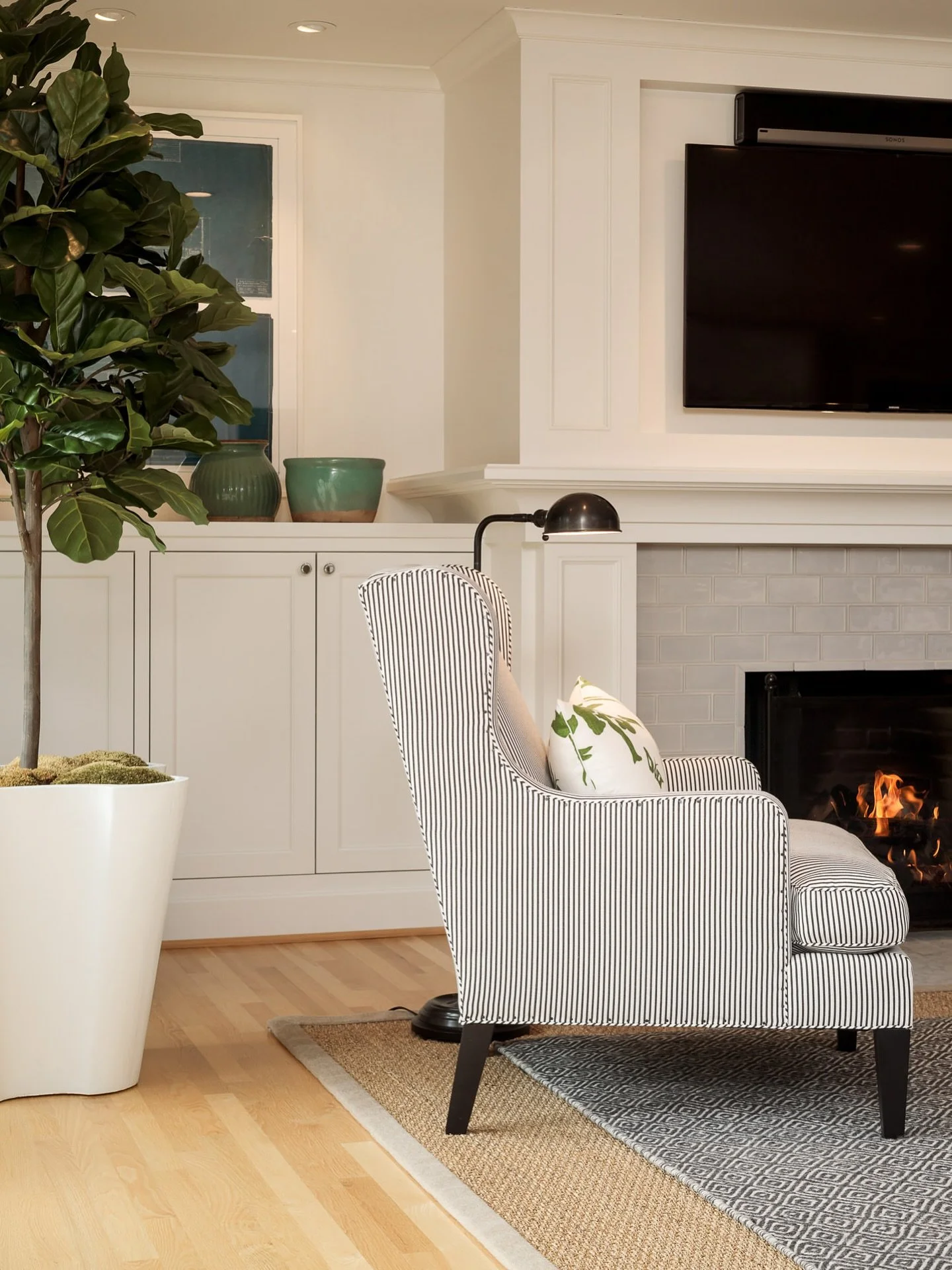 Cozy season is officially here 🍂 Nothing says fall like a crackling fireplace and a comfy chair to curl up in. This space feels extra inviting with layered textures, soft lighting, and a touch of greenery to balance the warmth.

#FallInteriors #Cozy