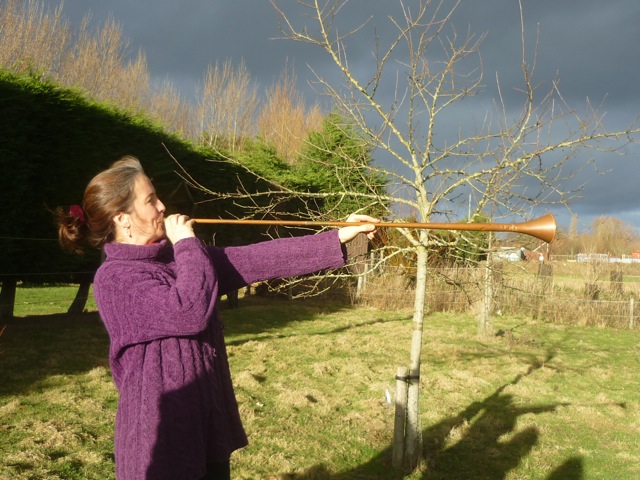 woman blowing wassail trumpet.jpeg