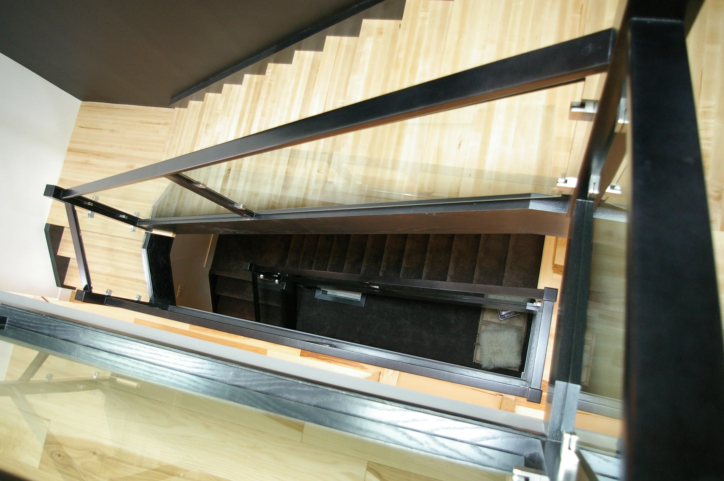  3 story open stairwell descending into black shag carpet basement.    