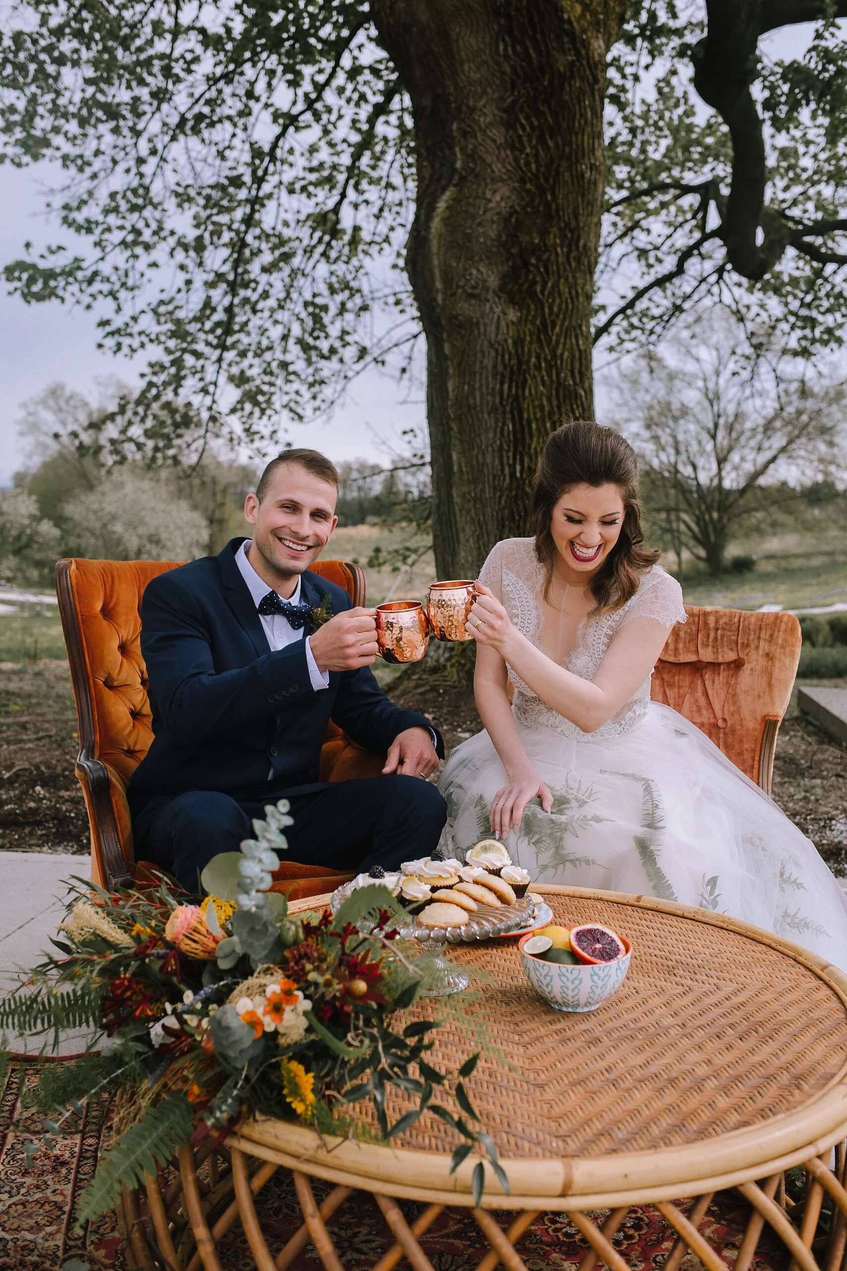 Outdoor bohemian lounge area from Vintage Alley Rentals at Chatham University, Eden Hall Farm designed by Exhale Events. Bride's look from Blanc de Blanc Bridal, Melissa Gown by Divine Atelier. Groom's suit from H&M.