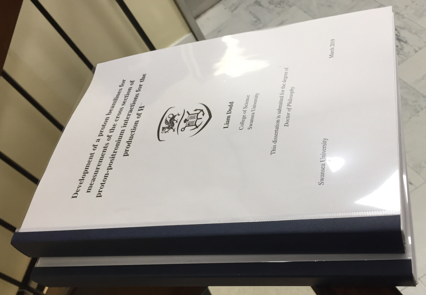 A finished thesis, balanced precariously upon a Bannister on the 6th floor of Vivian Tower.