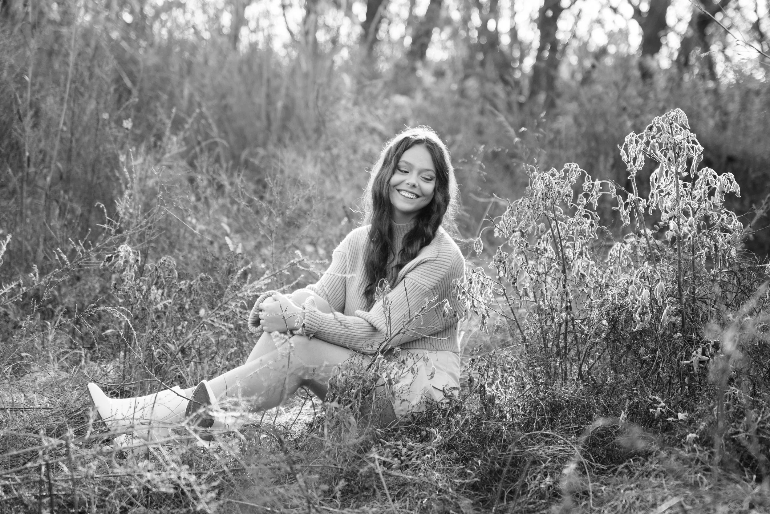 High school senior sitting in a fall field during her portrait session at Mead's Quarry in Knoxville, Tennessee