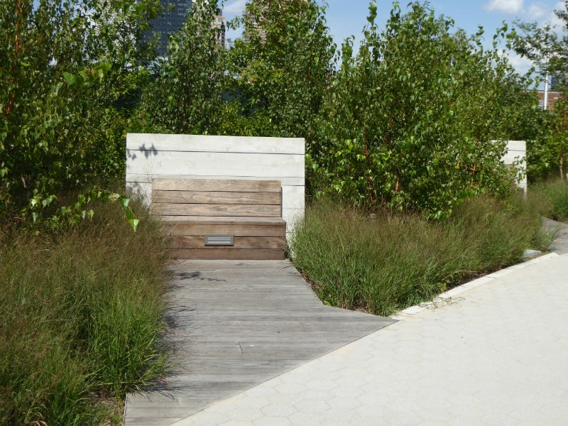 Seating adjoining waterfront path enclosed by planting