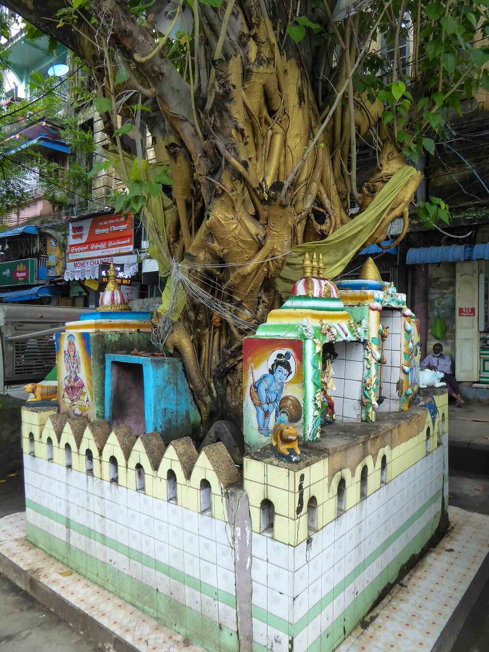 Hindu shrine in street at base of large Fig tree