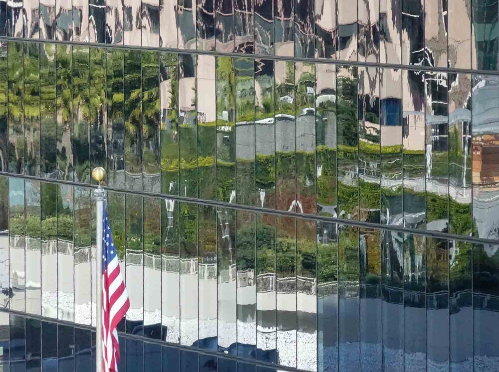 Reflection of park in fascade of adjoining highrise building