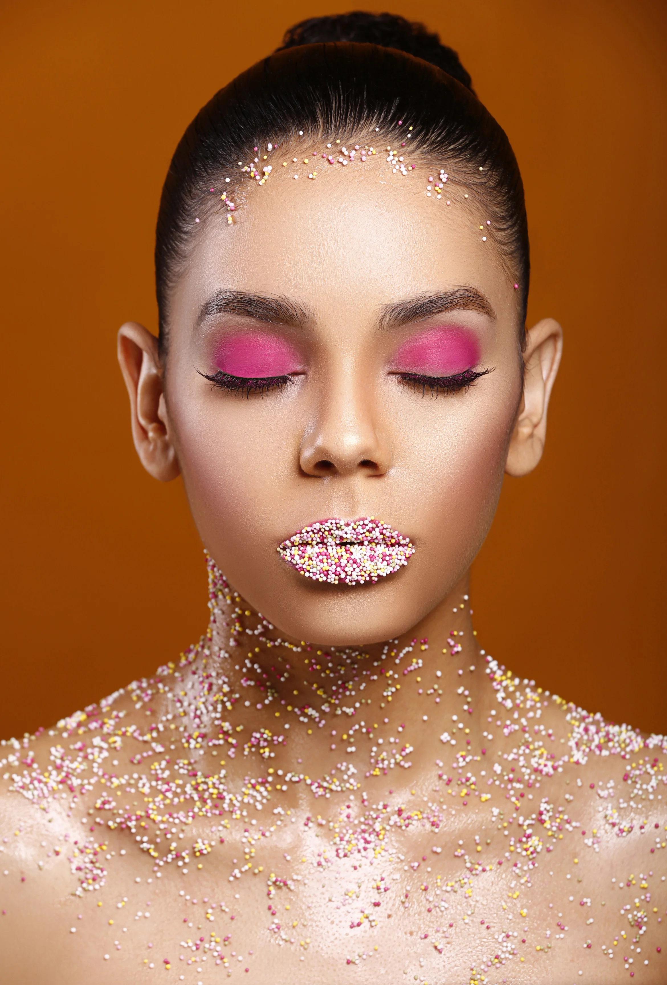For this look, i simply applied a thin layer of vaseline petrolum jelly all over her chest and sholder area. I then liberally sprinkled the sweets over the areas where i had applied vaseline and they immediately stuck, it was that simple :-) On the lips, i first of all applied a pink liquid lipsick with a lipgloss on top (the lipgloss was applied liberally as well) . I then sprinkled some sweets onto a tissue paper and asked the model to dip her lips in the sprinkles. We did this twice as there were still some gaps in between. Any strey sprinkles where simply dusted off with a brush. I also dubbed a little vaseline around hairline and placed more sprinkes.