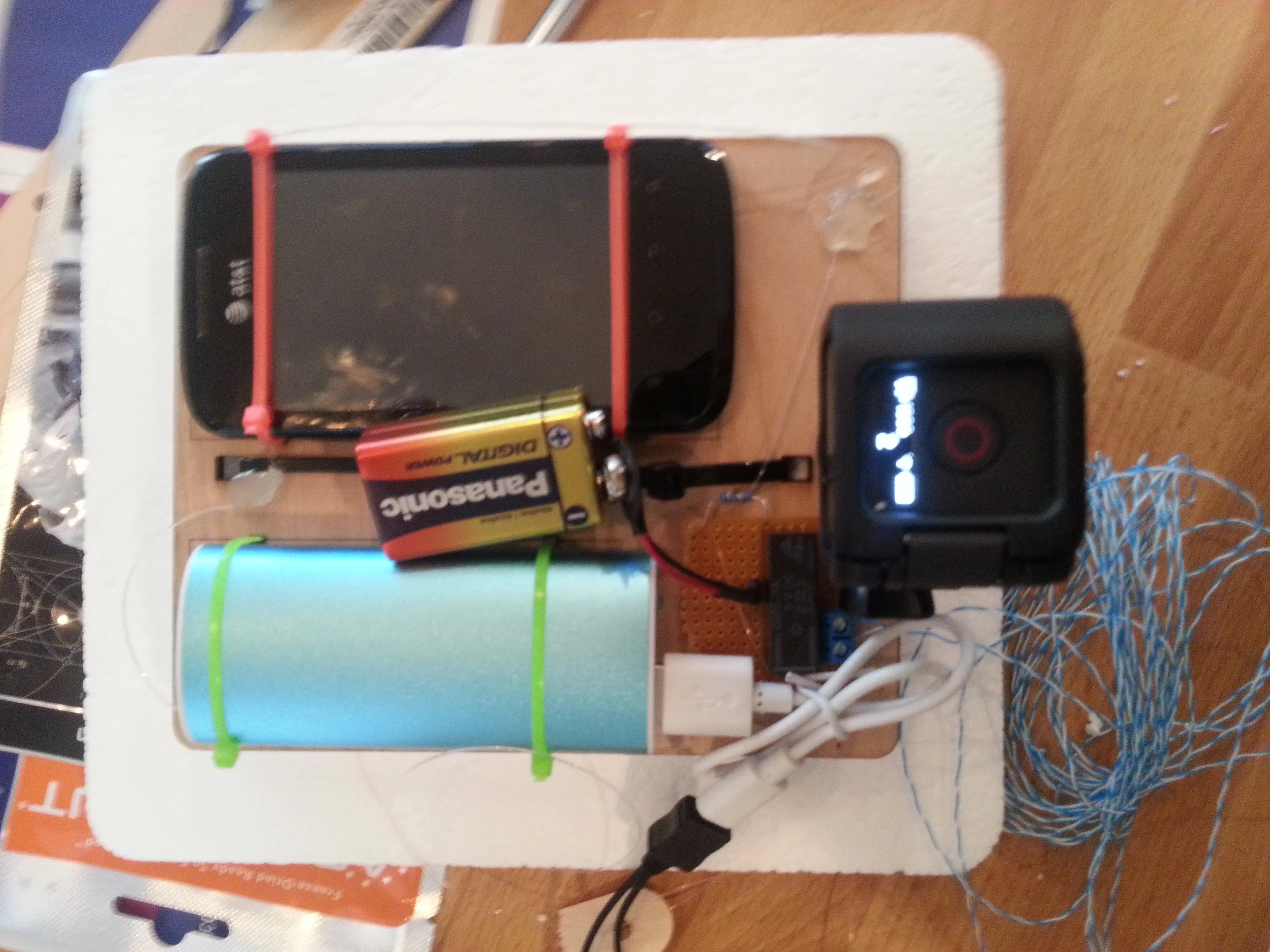 The top assembly of our Styrofoam payload, with tracking cell phone, backup battery, cut-down mechanism (aka wire burner), and GoPro
