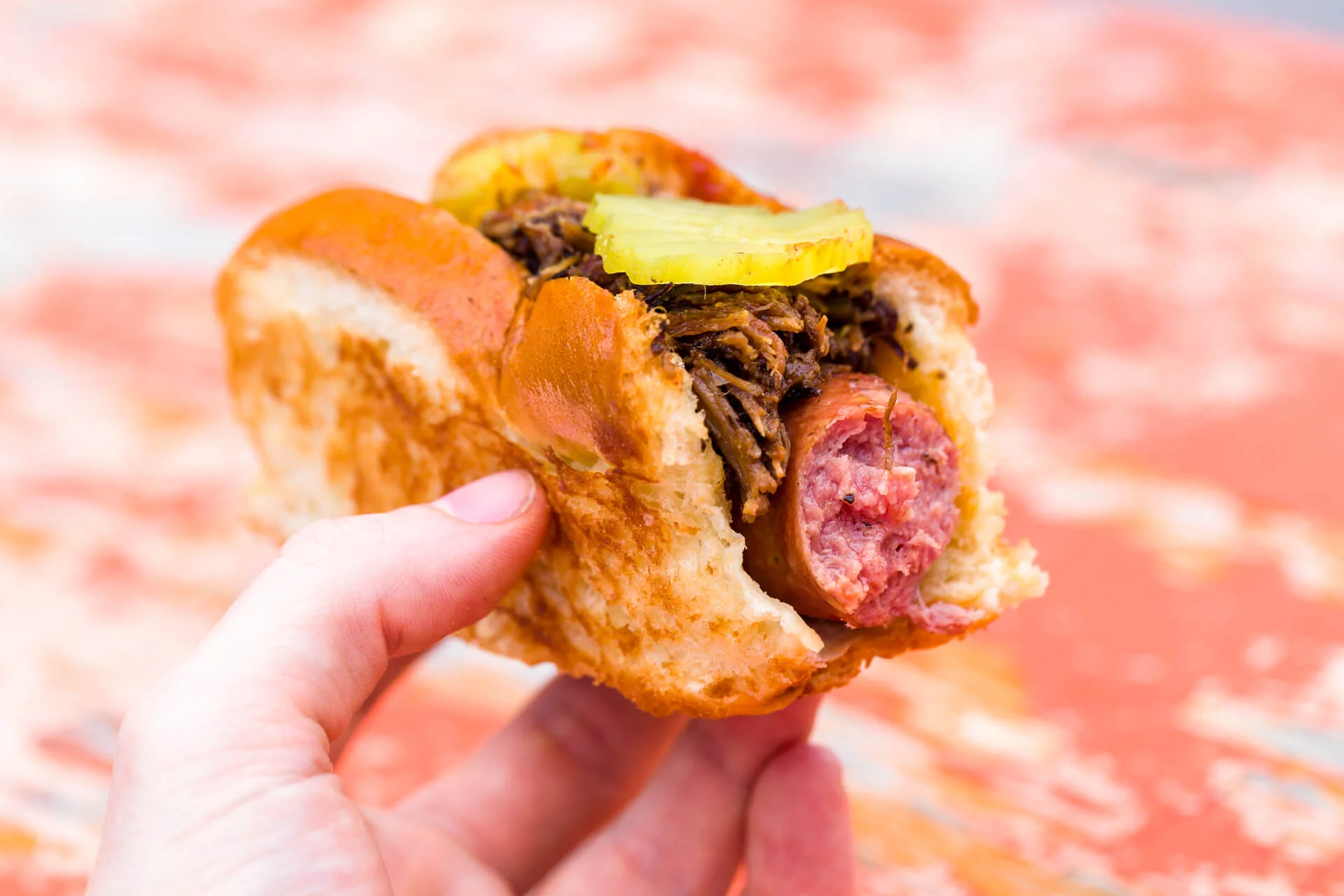 The Drag Dog: Local-made smoked beef dog with chopped brisket, Texas BBQ sauce, pickle, and onion on a custom-made Frank bun.