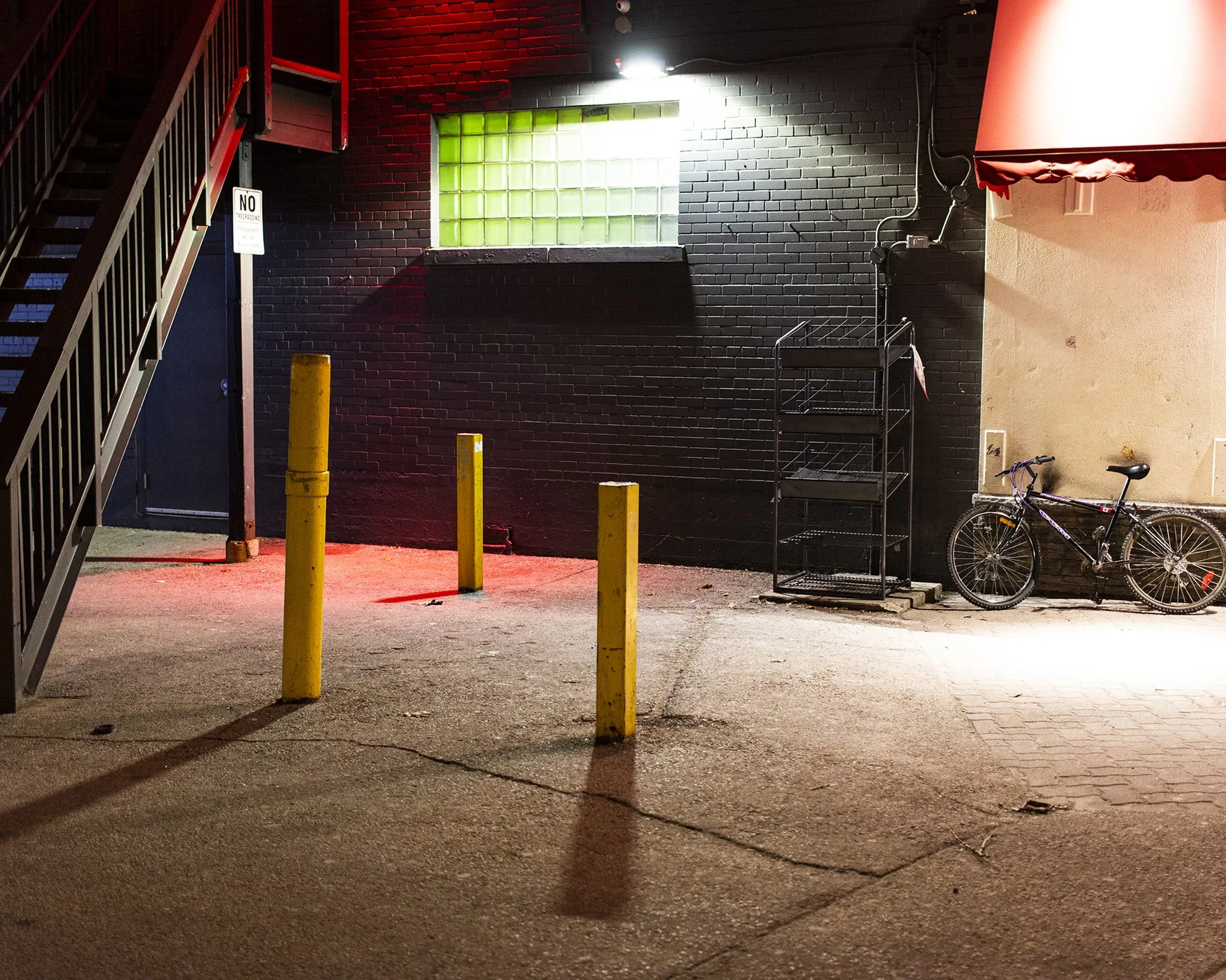 Black Brick 2011 - a photograph of a wall and area in downtown  London, Ontario. Red and green coloured lights illuminate the night streetscape