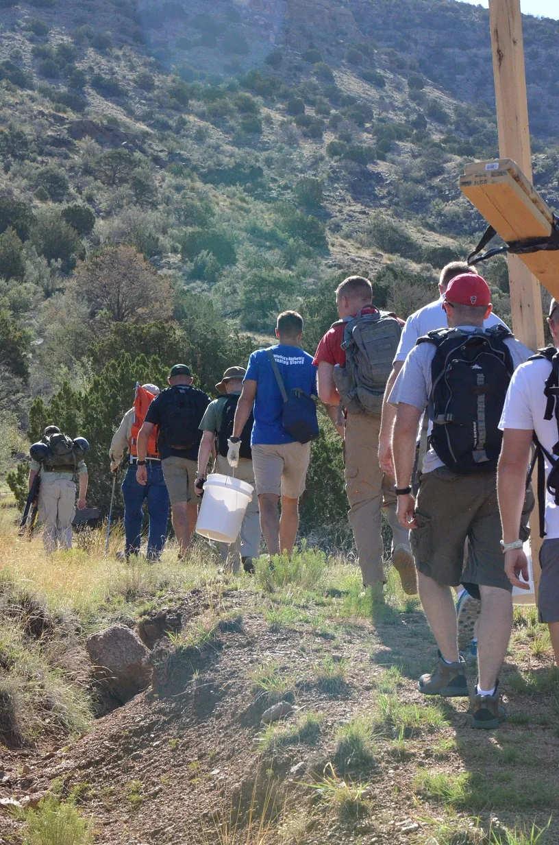  Students from the Defense Nuclear Weapons School Counter Proliferation Officer course help take cement and timber up to the mine. 