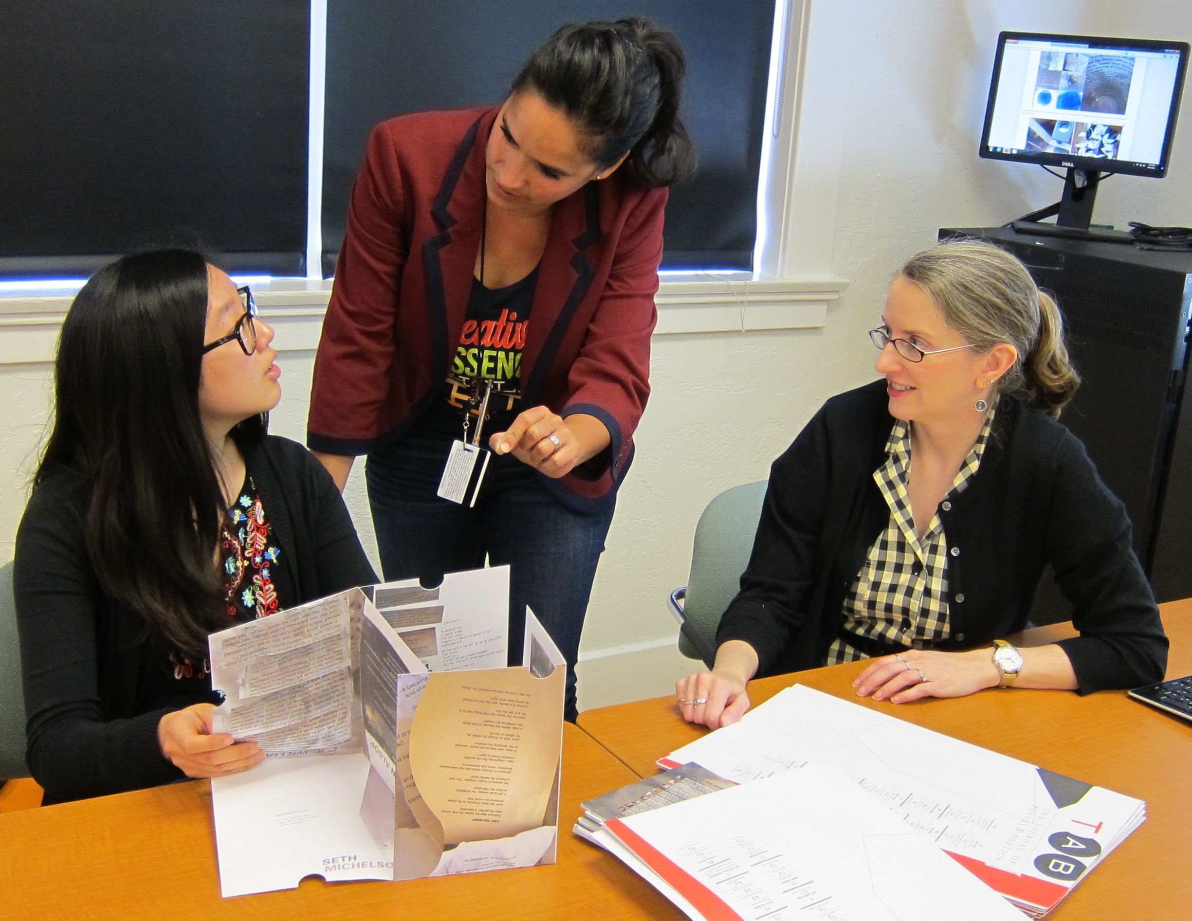 Professor of Art Claudine Jaenichen (middle) describes the interplay of time and space in TAB: Volume Two to Audrey Chang ’17 (left). Professor of English Anna Leahy, Ph.D. (right) explains how the content is selected, providing a wide range of poetic aesthetics.