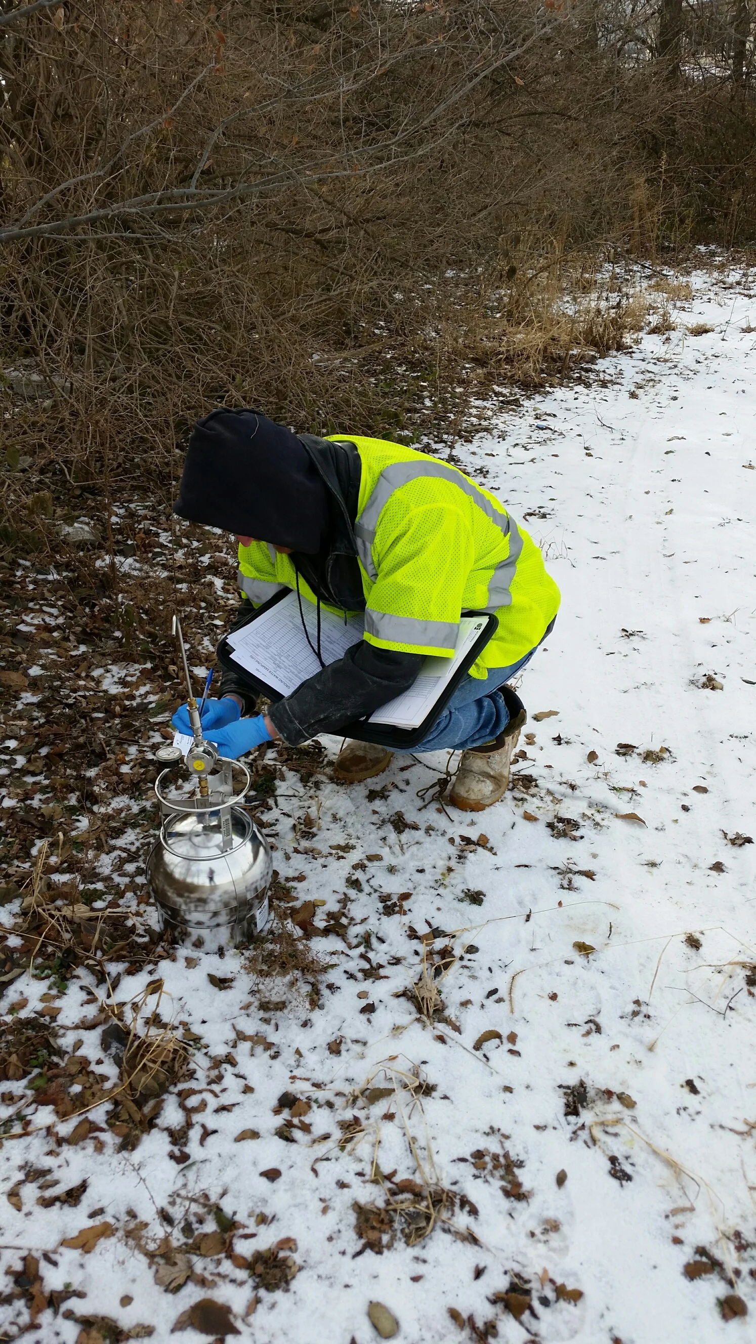 KERAMIDA staff geologist collecting an outdoor air sample using a Summa canister.