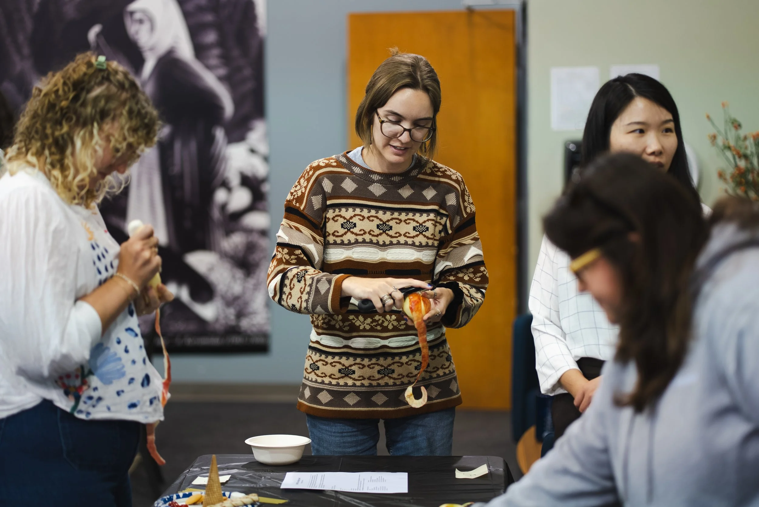  Serious concentration required for the apple peeling challenge. (Left to right: Genny Willman, PE, AAAE CM, Senior Manager, Compliance Engineering Services; Claudia Cozadd, MS, SCR, Senior Analyst, Sustainability; Xuqing Xiong, MS, PE, Vice Presiden