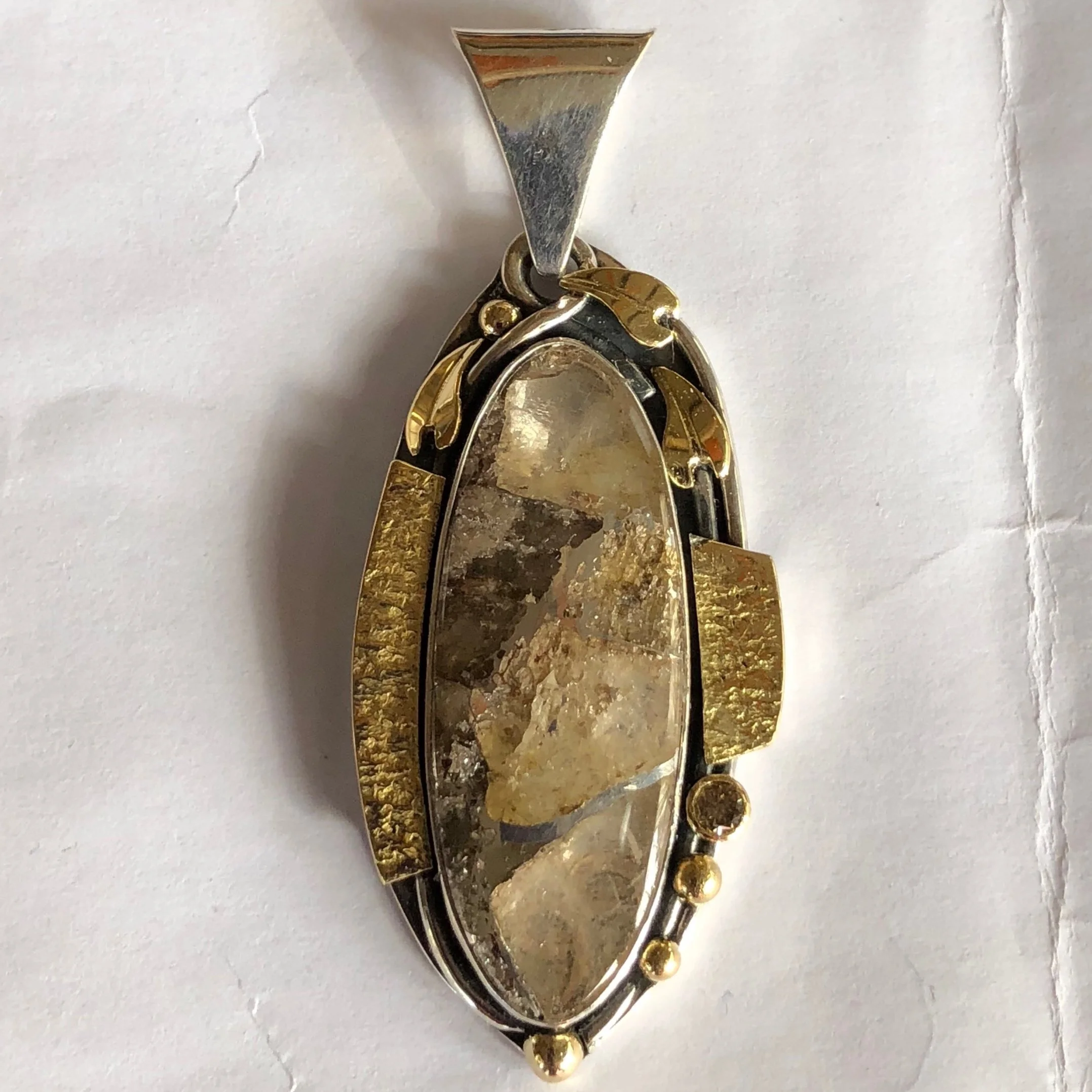 Matching pendant to clear quartz and silver earrings in silver and gold