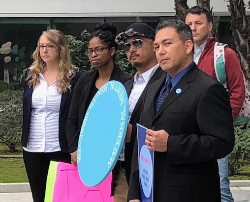 Jessica, Jessica and fathers watch father Rudy Coronado speak.