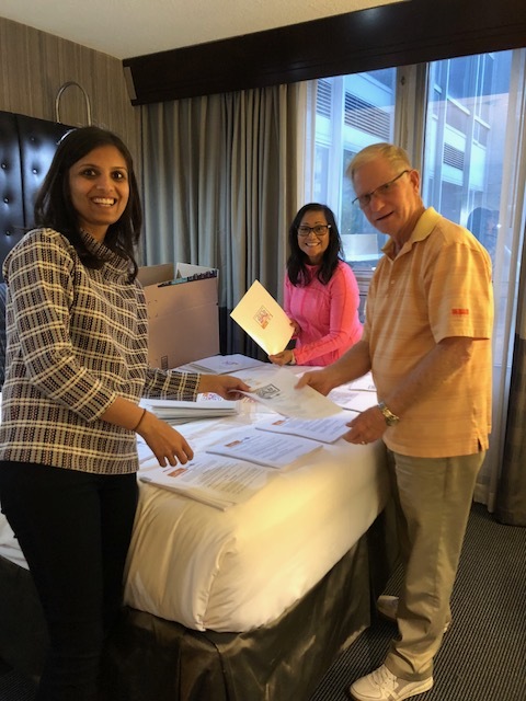 2020 Mom team stuffing registration folders. (Vrinda Devani, MD, board member; Millie Pagett, RN volunteer; Ed Pagett, volunteer and advocacy team member)